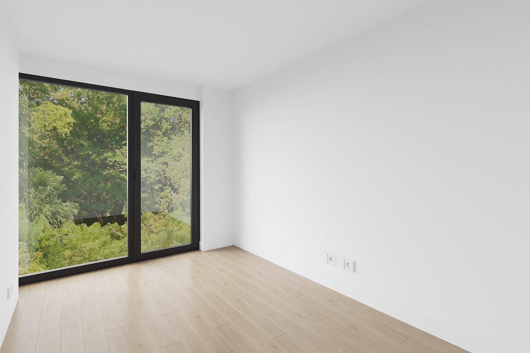 Leerer Raum mit großem Fenster und einem schönen Blick ins Grüne.