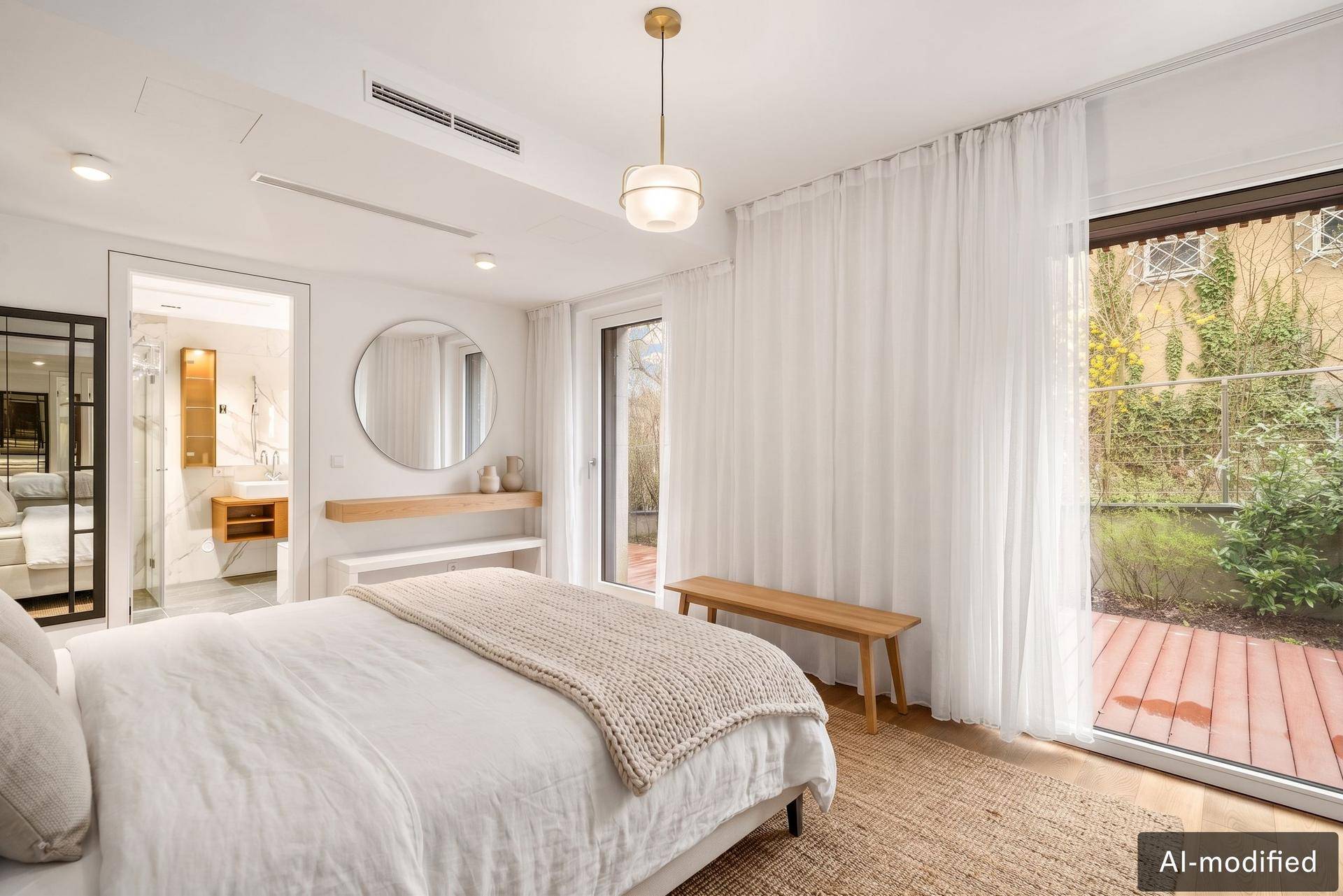 Helles Schlafzimmer mit großem Bett, Holzboden und direktem Zugang zu einer privaten Terrasse.