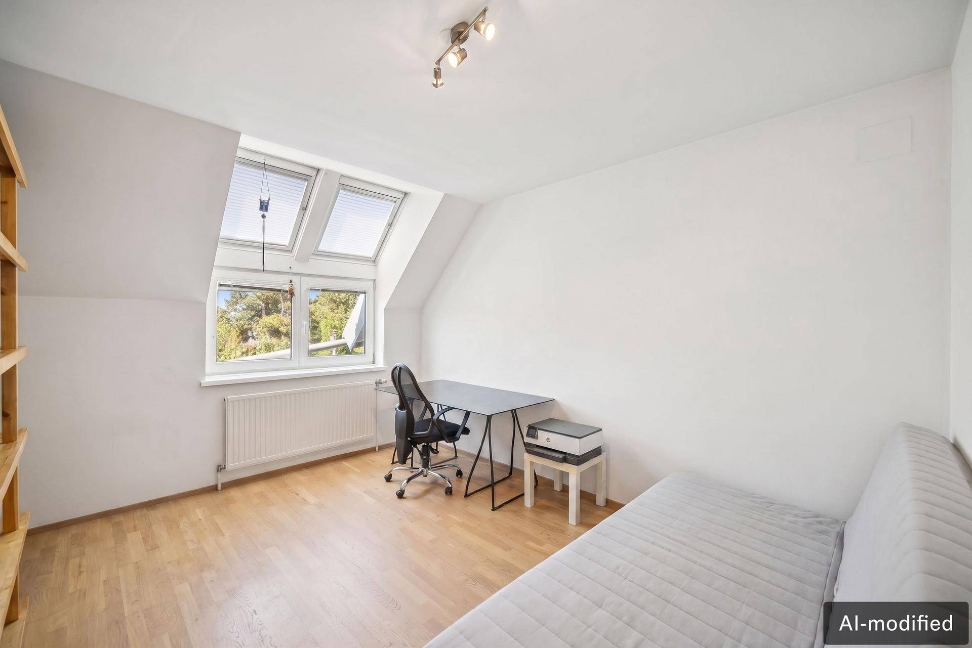 Helles Arbeitszimmer mit Dachfenstern, Holzboden und Blick ins Grüne.