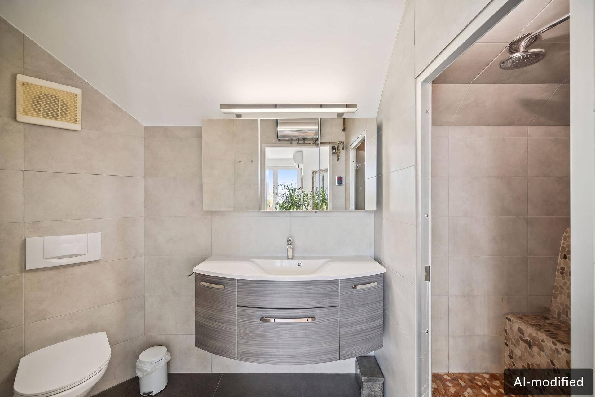 Modernes Badezimmer mit grauen Fliesen, Waschtisch und begehbarer Dusche.