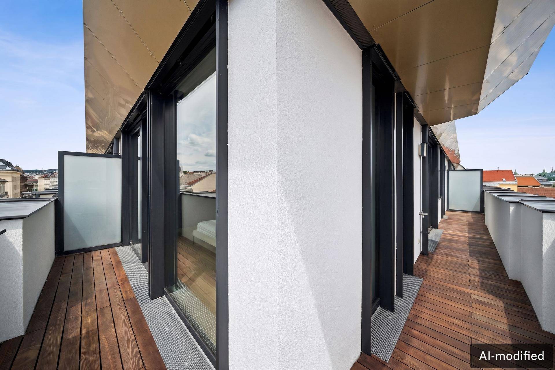 Langer Balkon mit Holzdeck und Blick auf die umliegenden Gebäude.