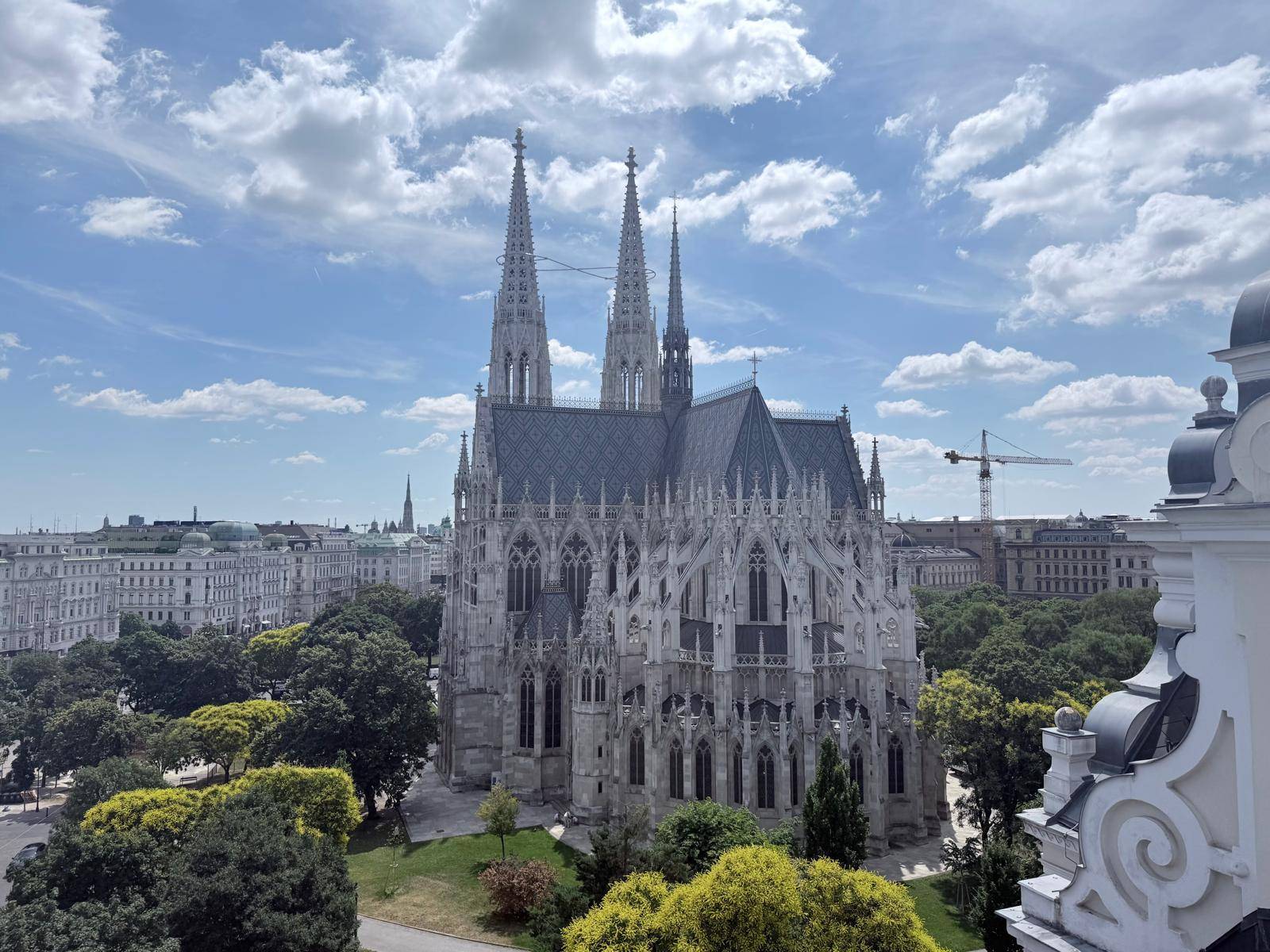 Panoramablick auf eine prächtige gotische Kirche und die umliegende Stadtlandschaft unter blauem Himmel.