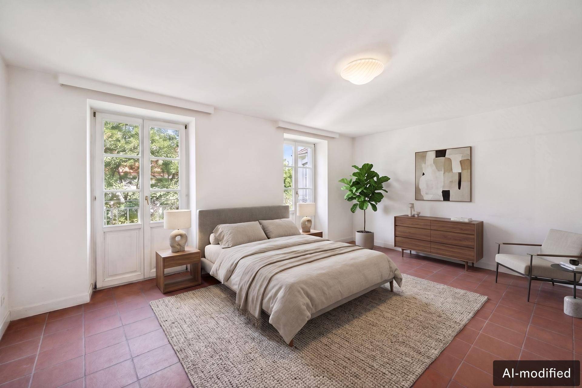 Modern eingerichtetes Schlafzimmer mit Terrakotta-Boden, großen Fenstern und viel Tageslicht.