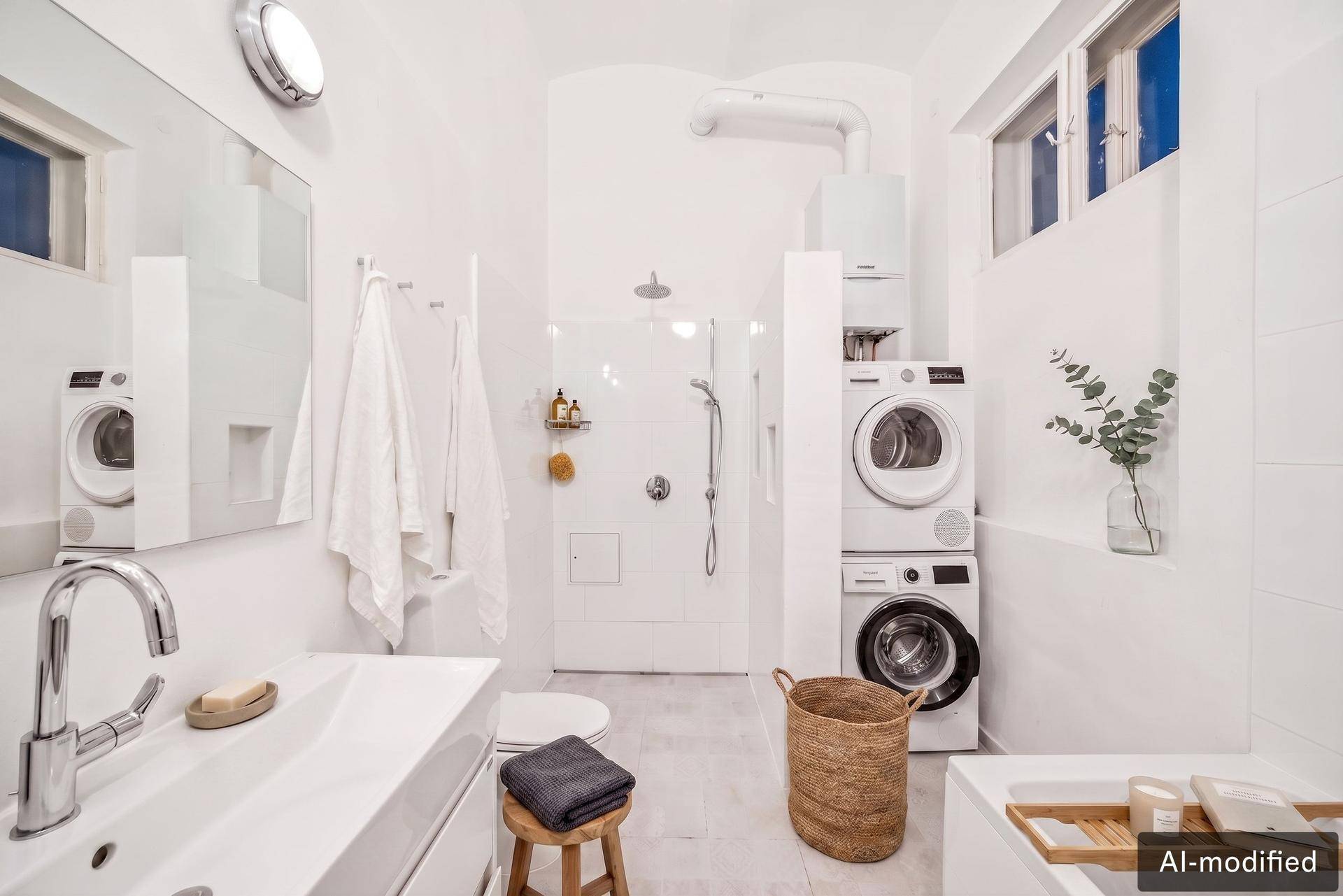 Modernes Badezimmer mit Dusche, Waschmaschine und Trockner, sowie einem Fenster für natürliche Belüftung.