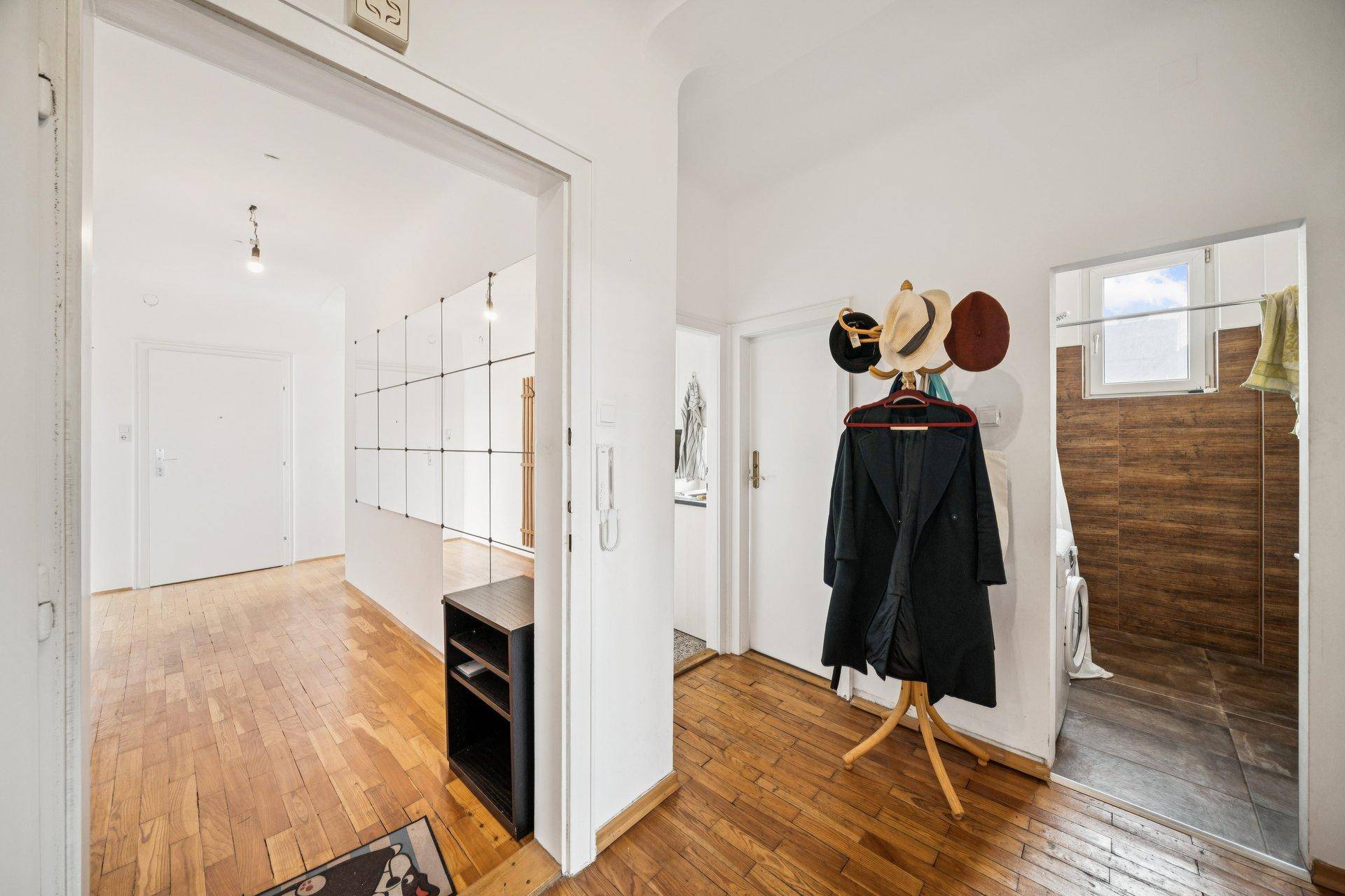 Eingangsbereich mit Holzboden, Garderobe und Zugang zu weiteren Räumen.