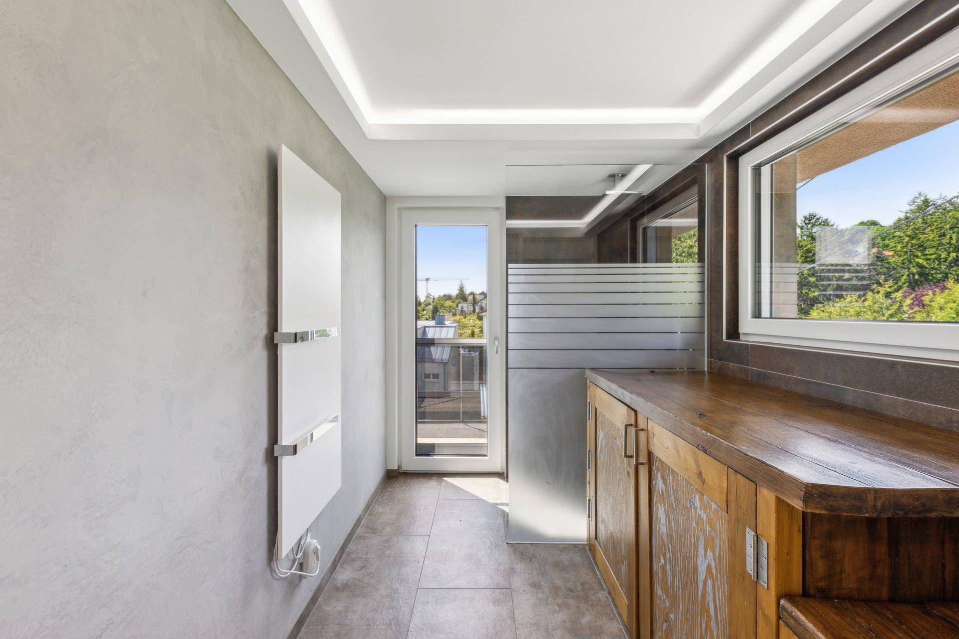 Modernes Badezimmer mit Holzwaschtisch, Fenster und beheiztem Handtuchhalter.