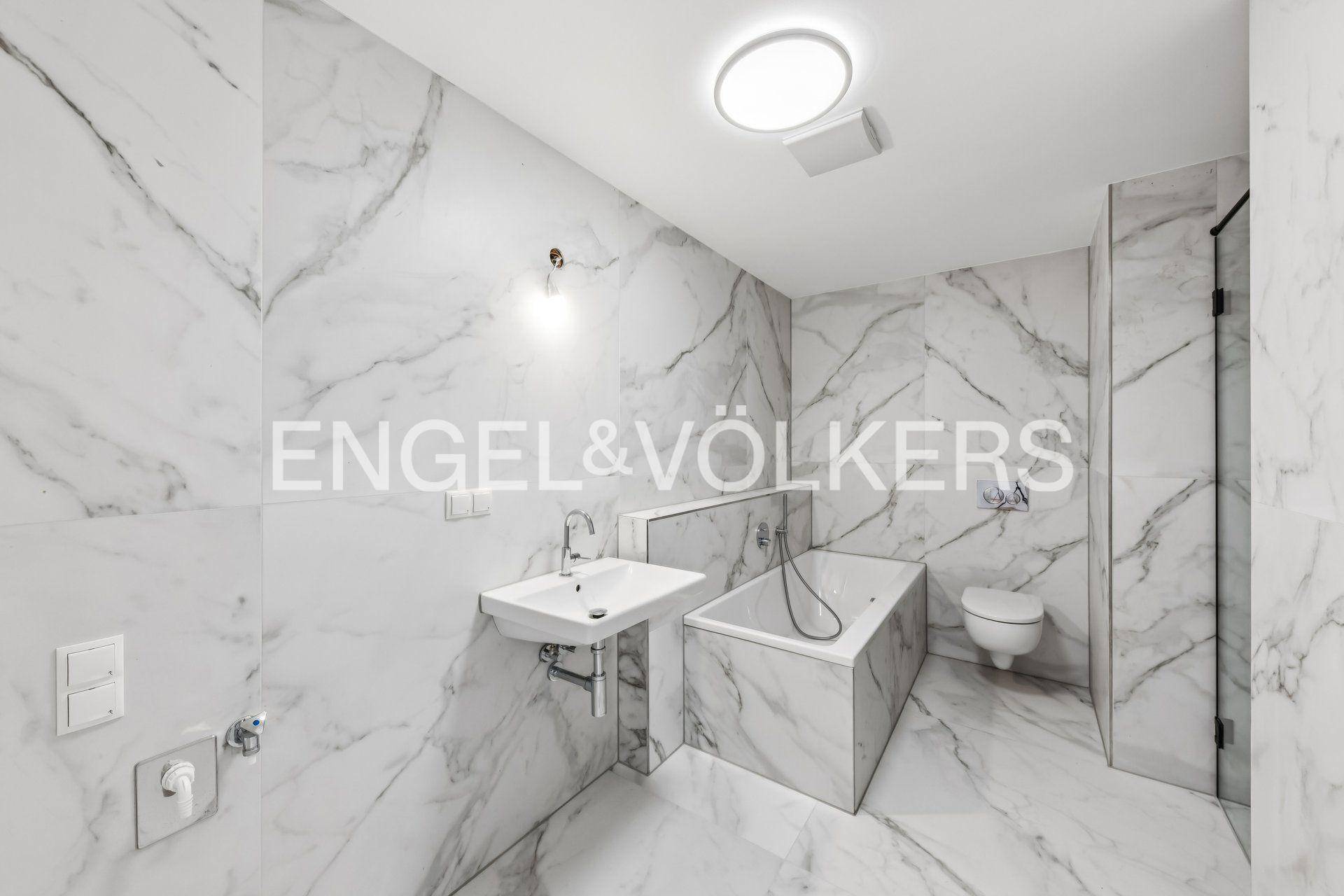 Modernes Badezimmer mit Marmorfliesen, Badewanne und separater Dusche in elegantem Design.