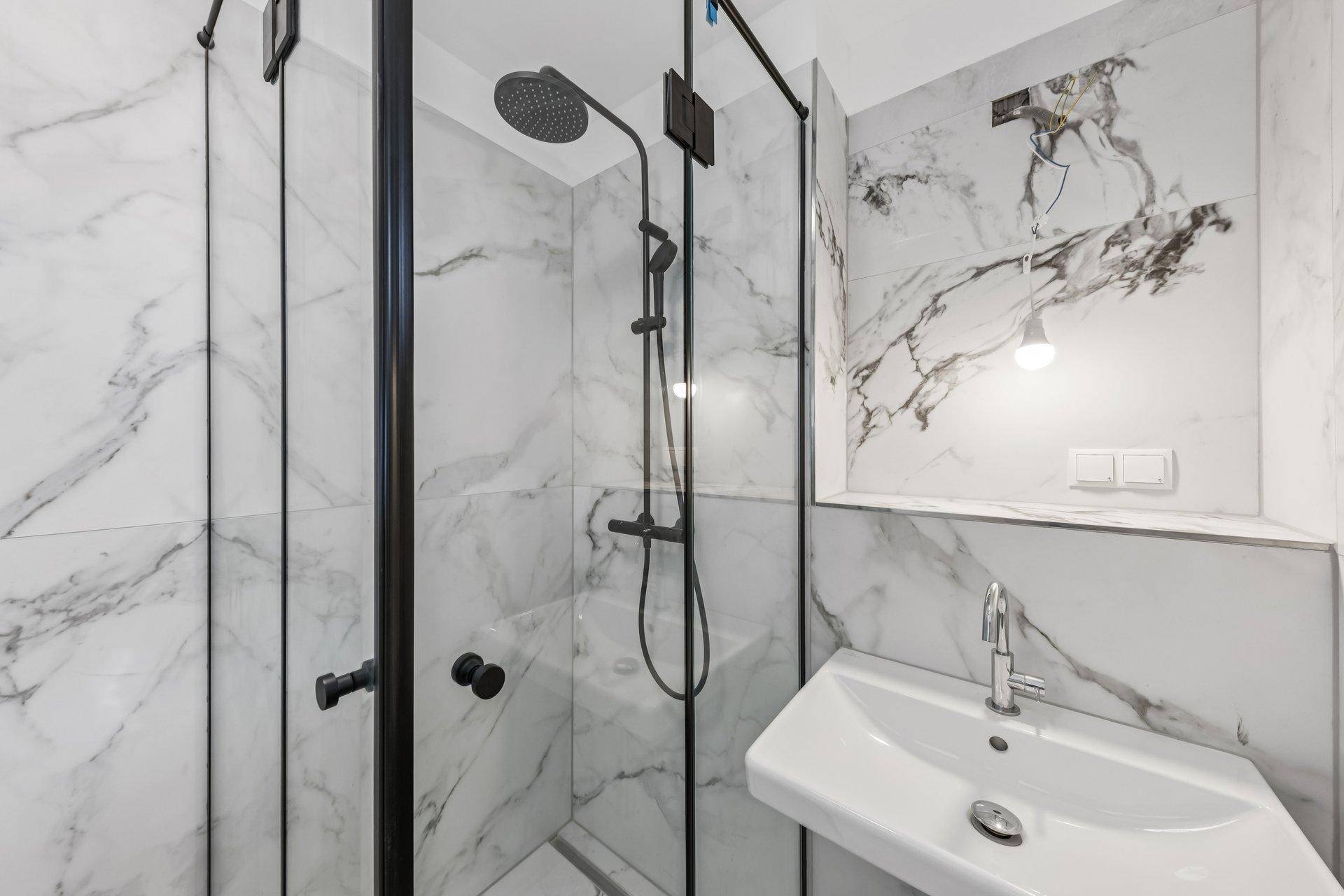 Modernes Badezimmer mit begehbarer Dusche, Marmorfliesen und stilvollem Waschtisch.