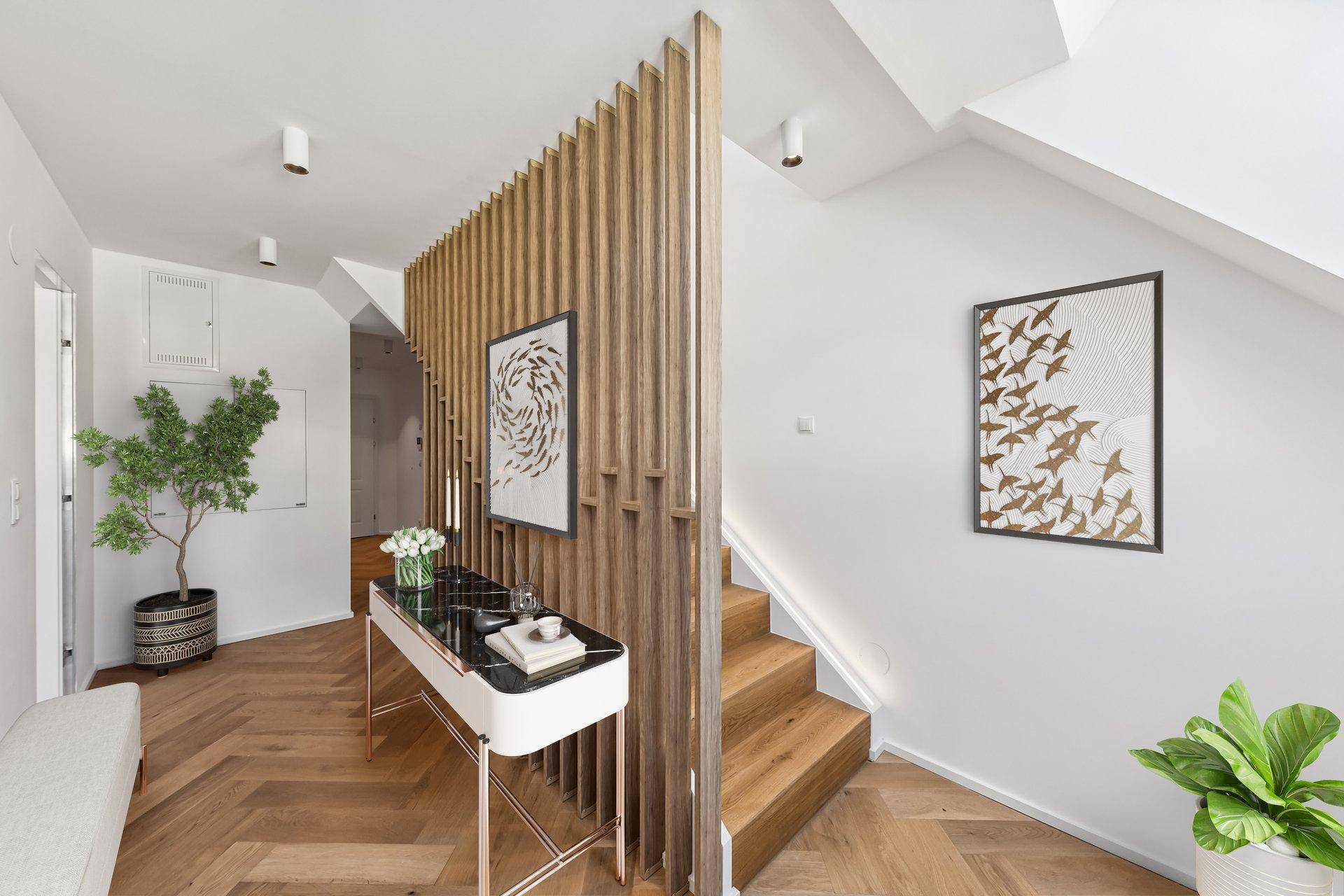 Moderner Eingangsbereich mit Holzlamellenwand, Fischgrätparkett und Treppe zum Obergeschoss.