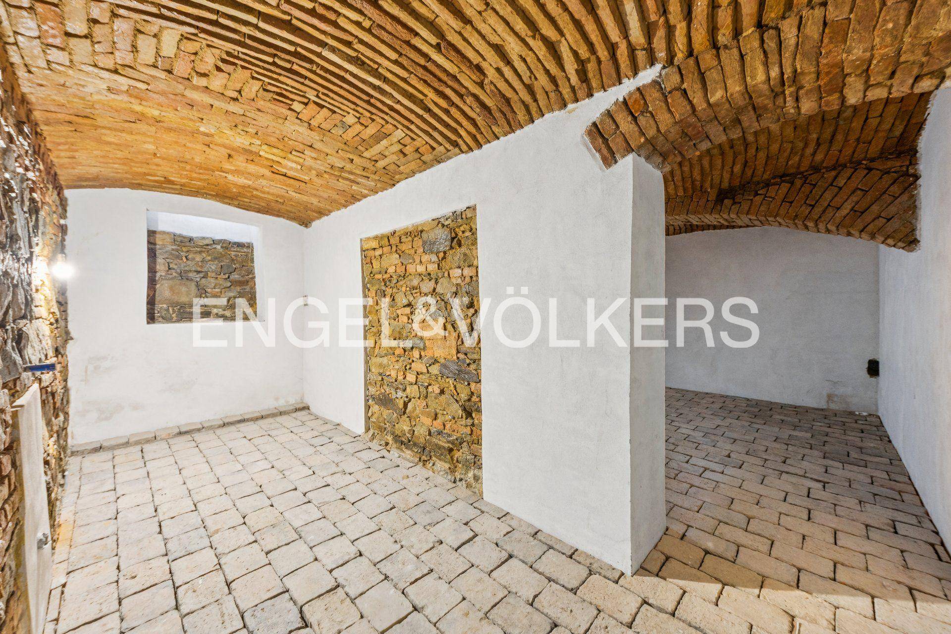 Historischer Kellerraum mit beeindruckenden Ziegelgewölbedecken und Steinboden.