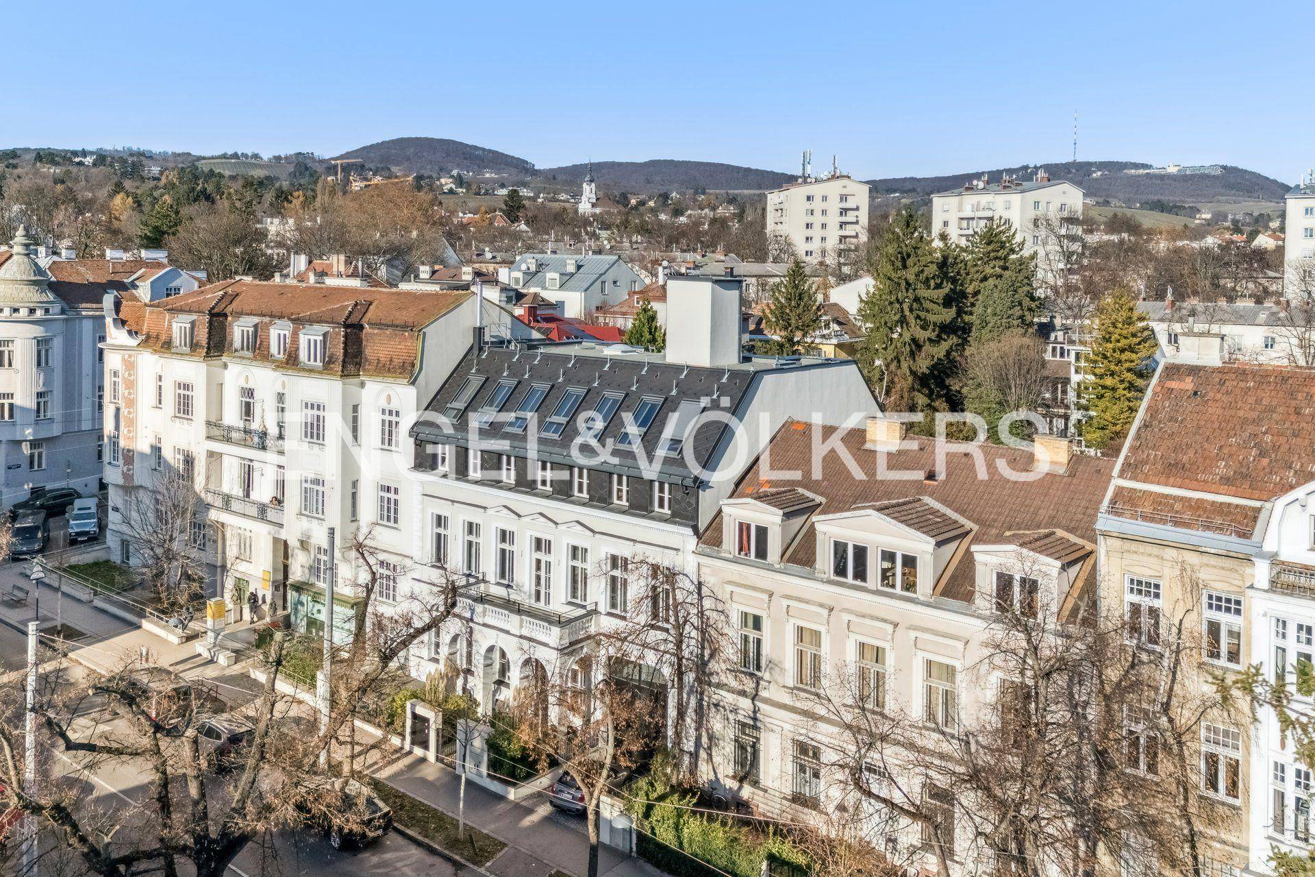 Panoramablick auf das Wohngebäude und die umliegende Stadtlandschaft mit grünen Hügeln.