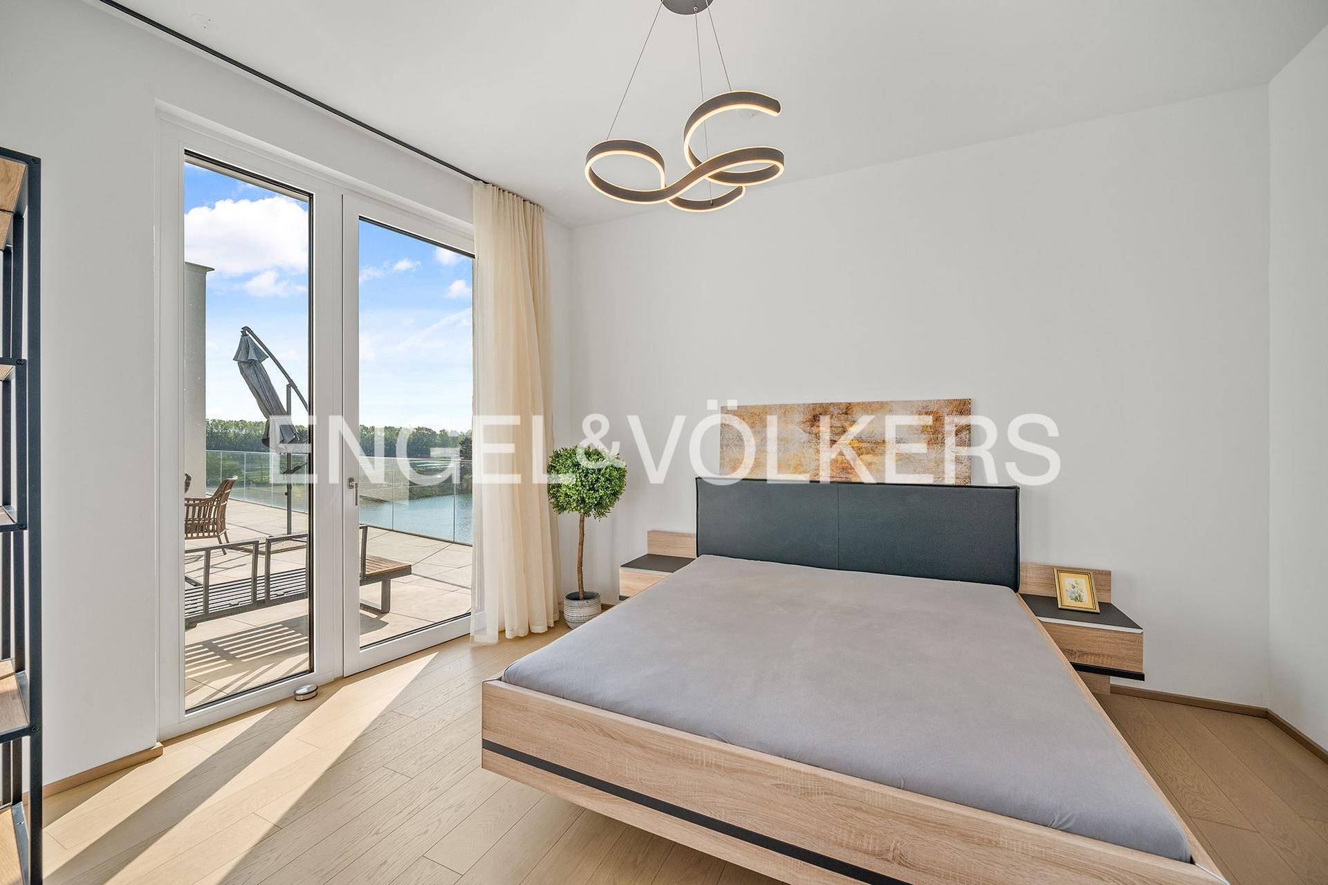 Modernes Schlafzimmer mit Holzbett, Parkettboden und direktem Zugang zur Terrasse.