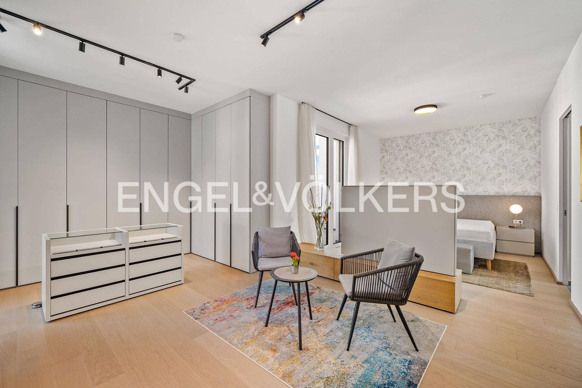 Geräumiges Schlafzimmer mit Einbauschränken, Sitzgelegenheiten und modernem Design.