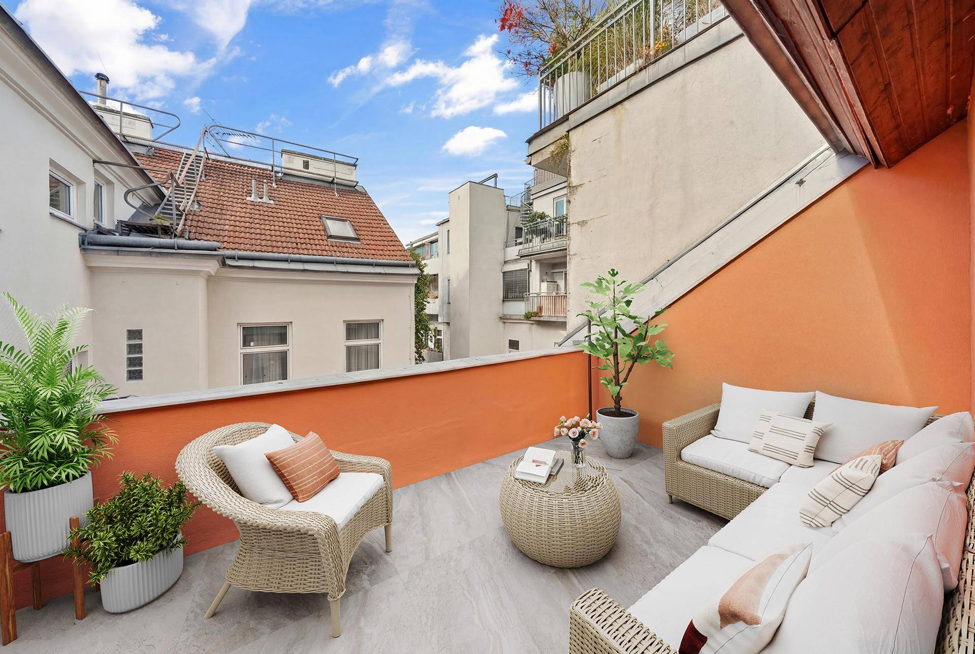 Gemütliche Dachterrasse mit Sitzgelegenheiten und Blick auf die umliegenden Gebäude.