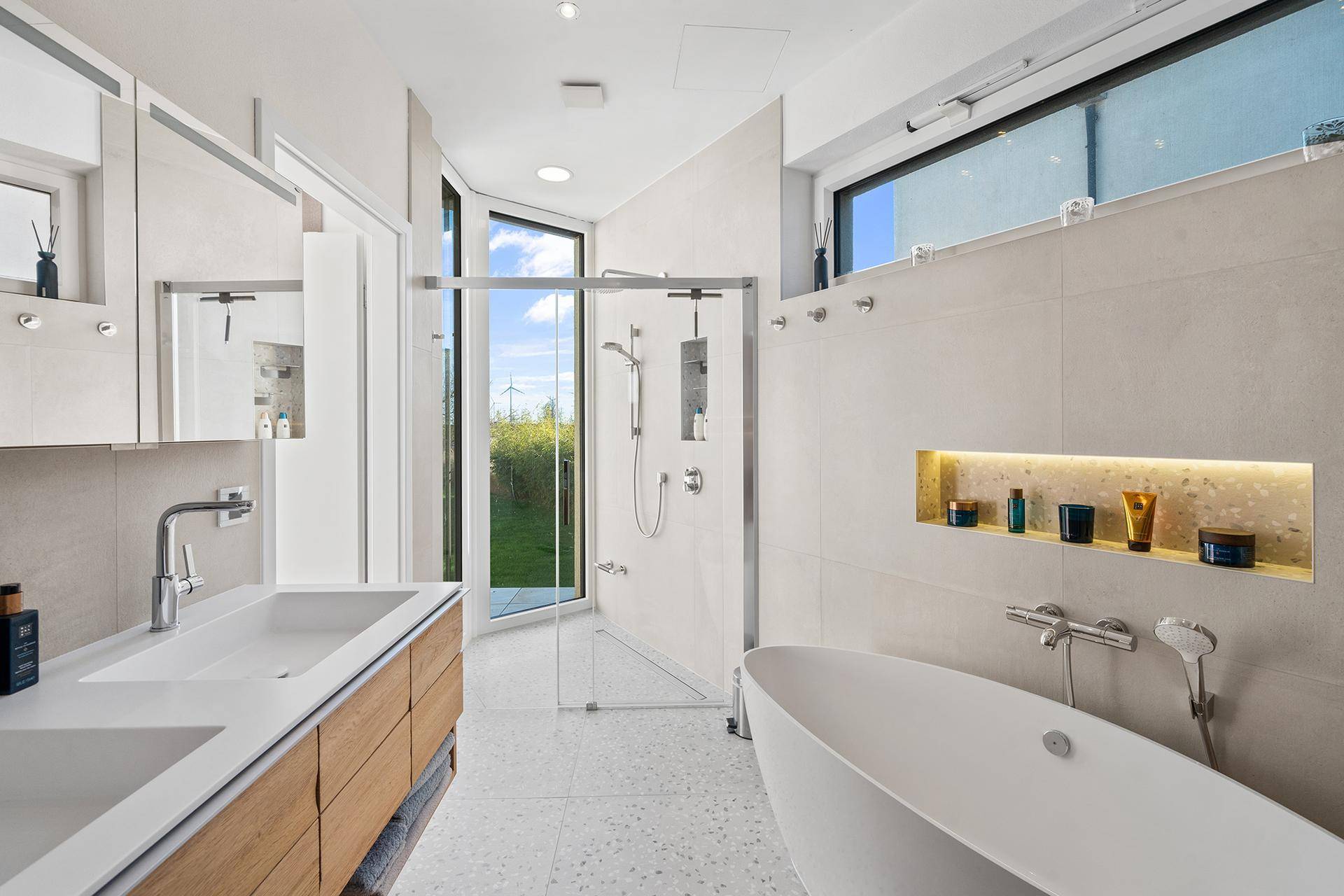 Modernes Badezimmer mit freistehender Badewanne, begehbarer Dusche und großem Fenster.