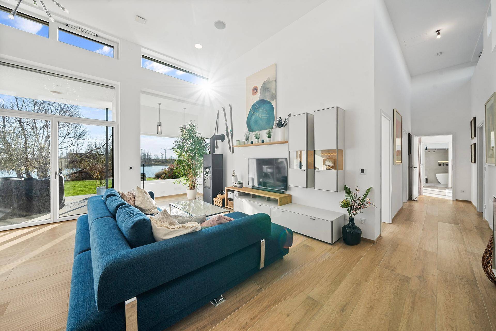 Helles Wohnzimmer mit Seeblick, großen Fenstern und modernem Interieur.
