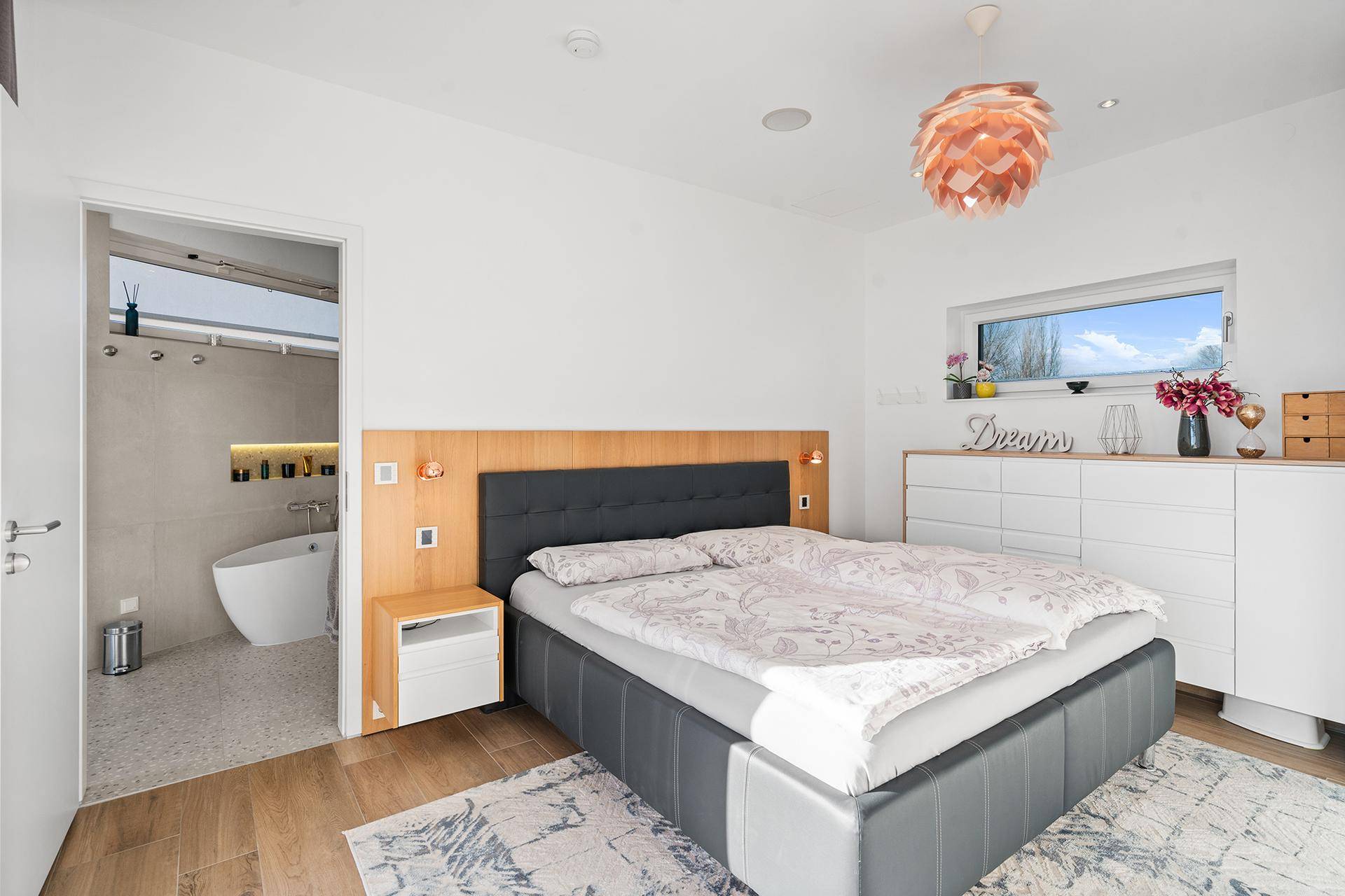 Helles Schlafzimmer mit modernem Bett und direktem Zugang zu einem luxuriösen Badezimmer.