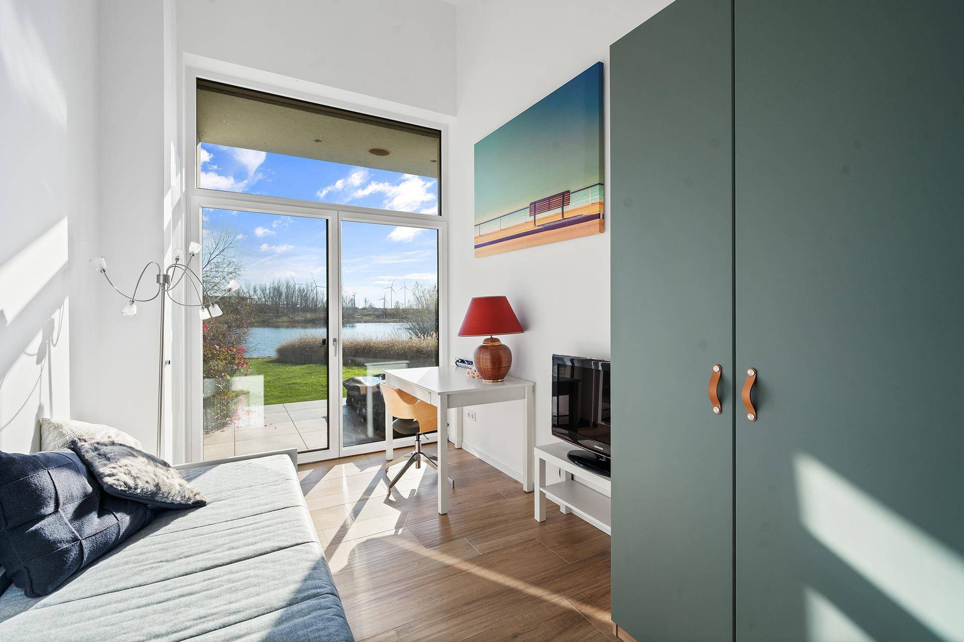 Helles Arbeitszimmer mit Seeblick, großen Fenstern und Zugang zur Terrasse.