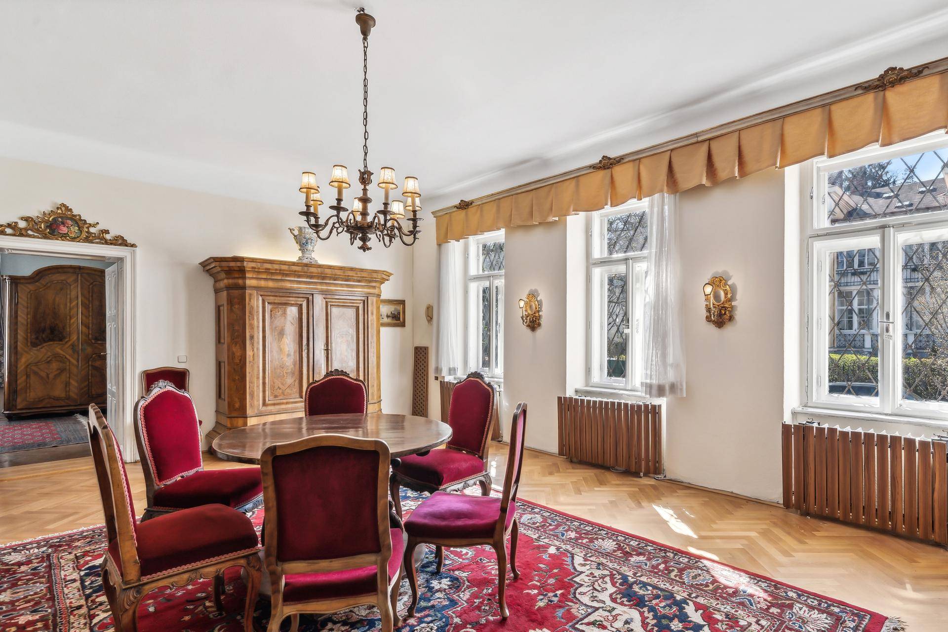 Elegantes Esszimmer mit traditionellen Möbeln, Parkettboden und großen Fenstern.