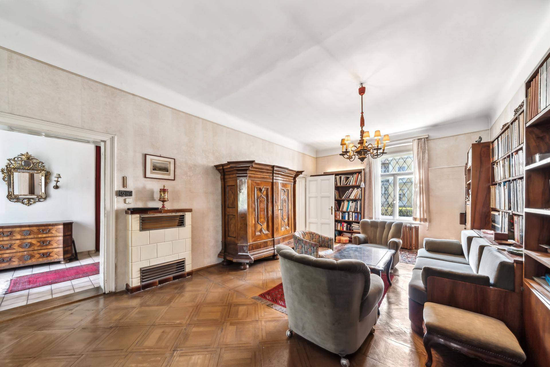 Gemütliches Wohnzimmer mit Parkettboden, Kachelofen und traditionellen Holzmöbeln.