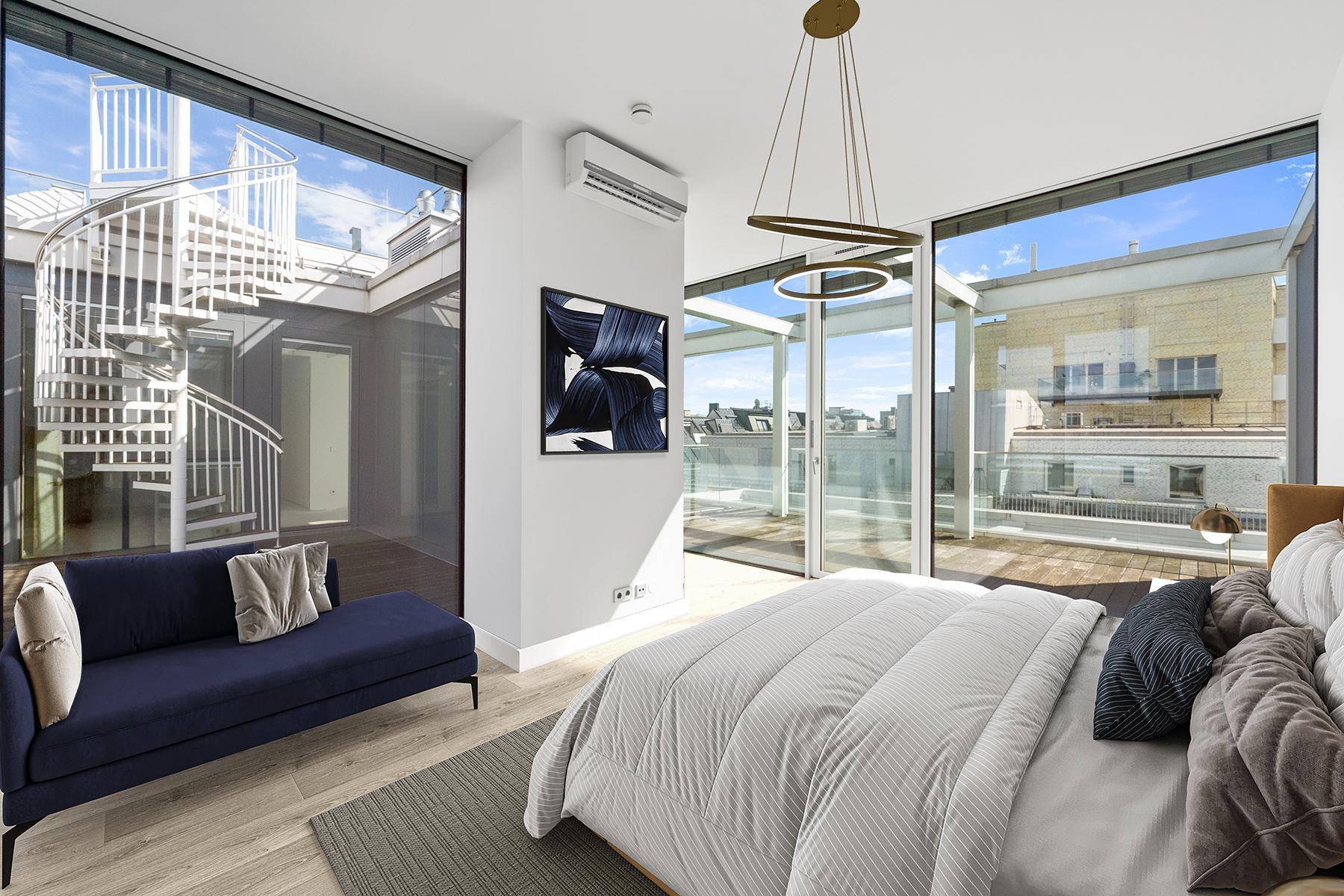 Helles Schlafzimmer mit großen Fenstern, Zugang zur Terrasse und einer Wendeltreppe im Außenbereich.