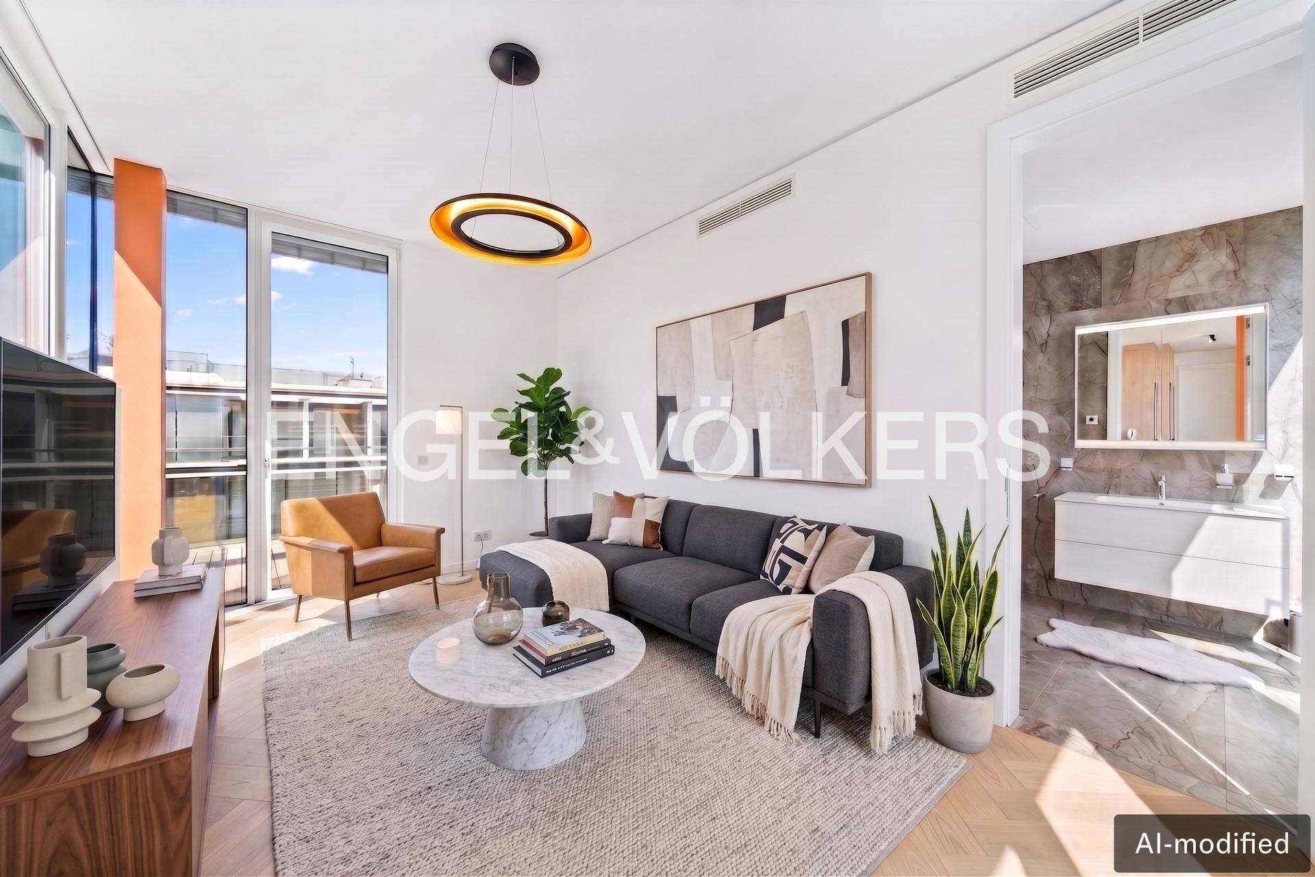 Gemütliches Wohnzimmer mit Sofa, Holzboden und Blick auf das angrenzende Badezimmer.