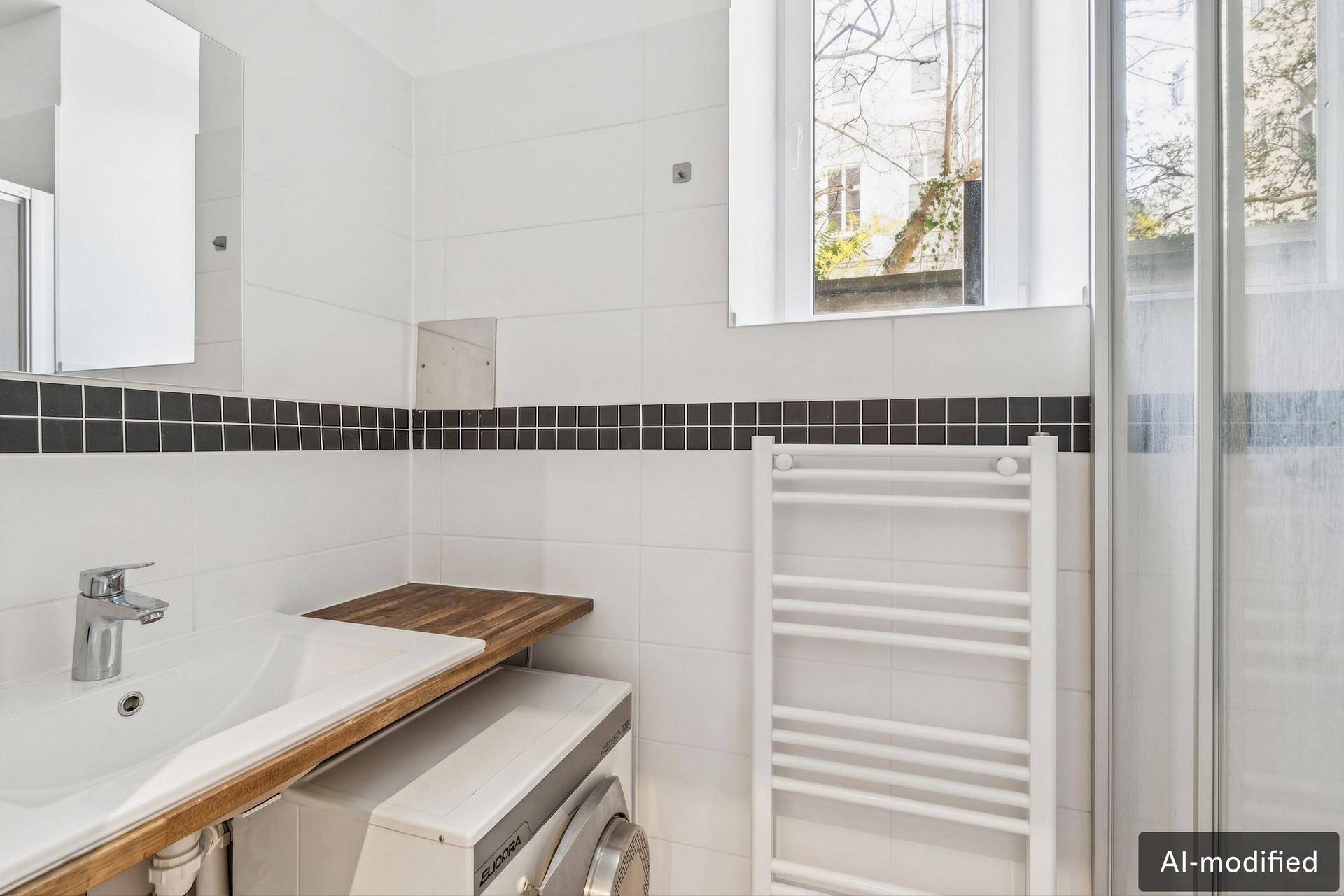 Modernes Badezimmer mit weißen Fliesen, Dusche, Waschmaschine und beheiztem Handtuchhalter.
