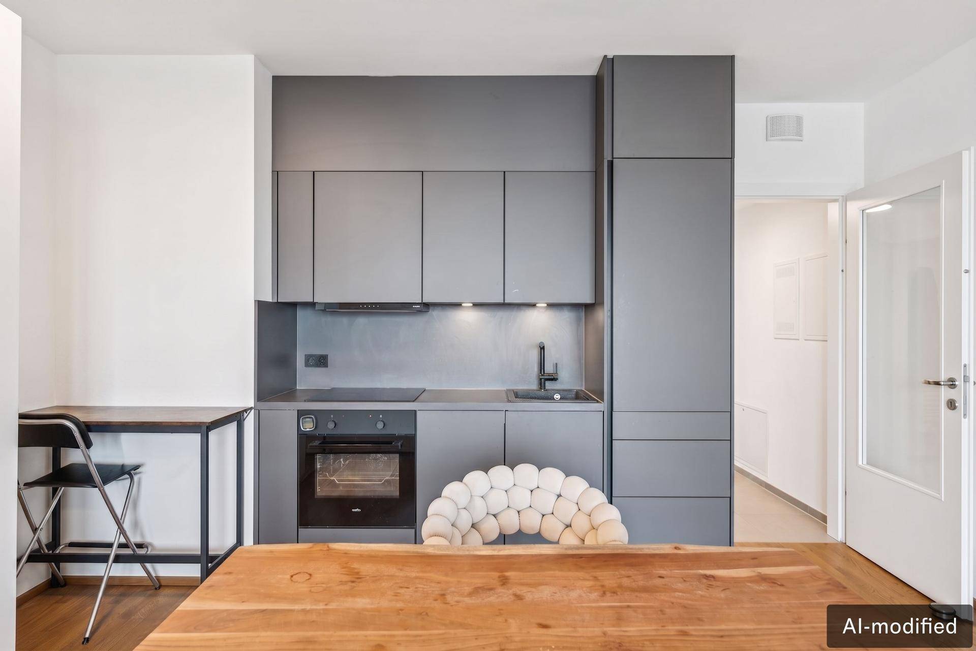 Kompakte, moderne Küchenzeile in Grau mit integriertem Backofen und Spülbecken.