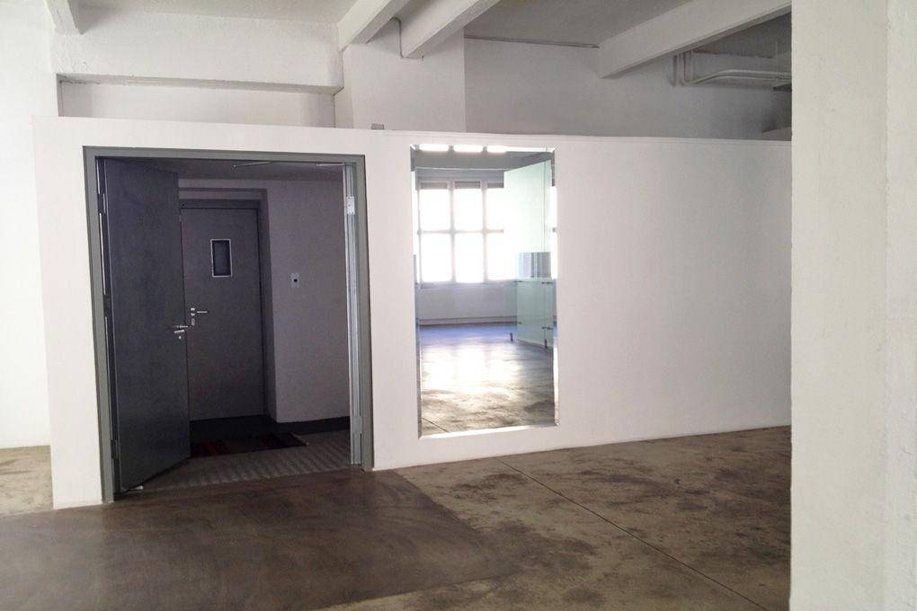 Eingangsbereich mit offener Tür und Blick in einen angrenzenden Raum mit Fenster.