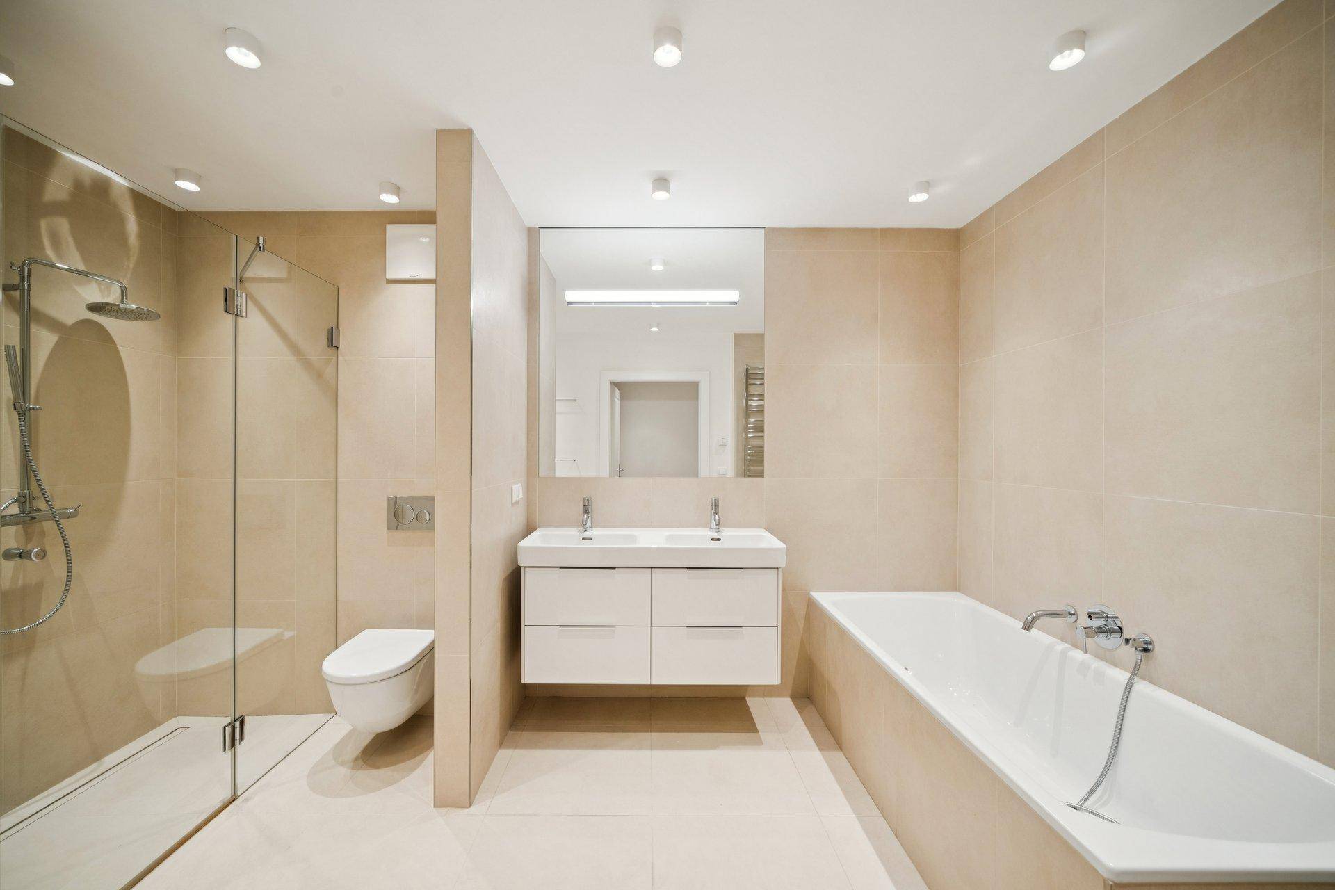 Modernes Badezimmer mit Doppelwaschbecken, Badewanne und ebenerdiger Dusche.