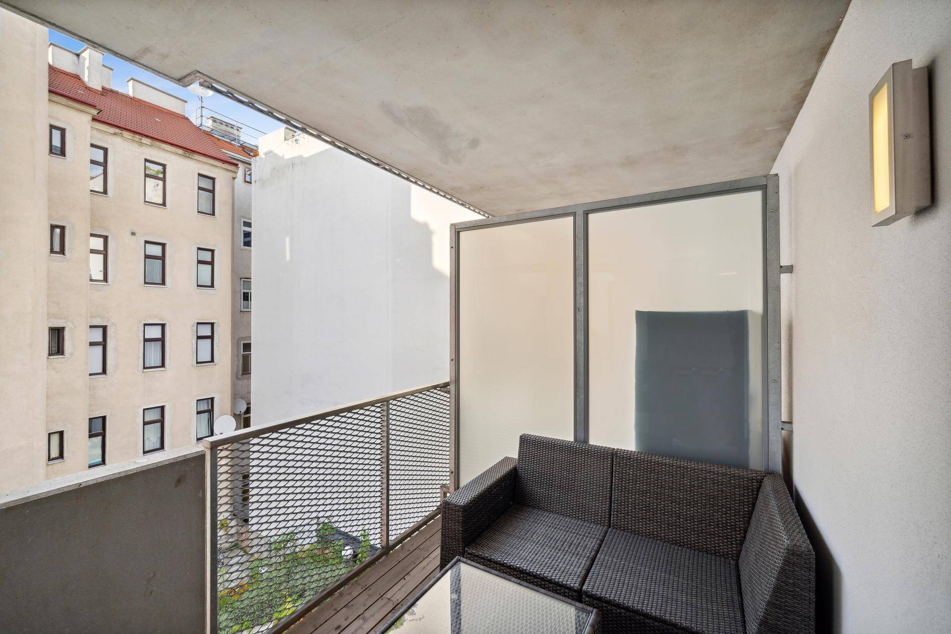 Gemütlicher Balkon mit Sitzgelegenheiten und Blick auf die umliegenden Stadtgebäude.