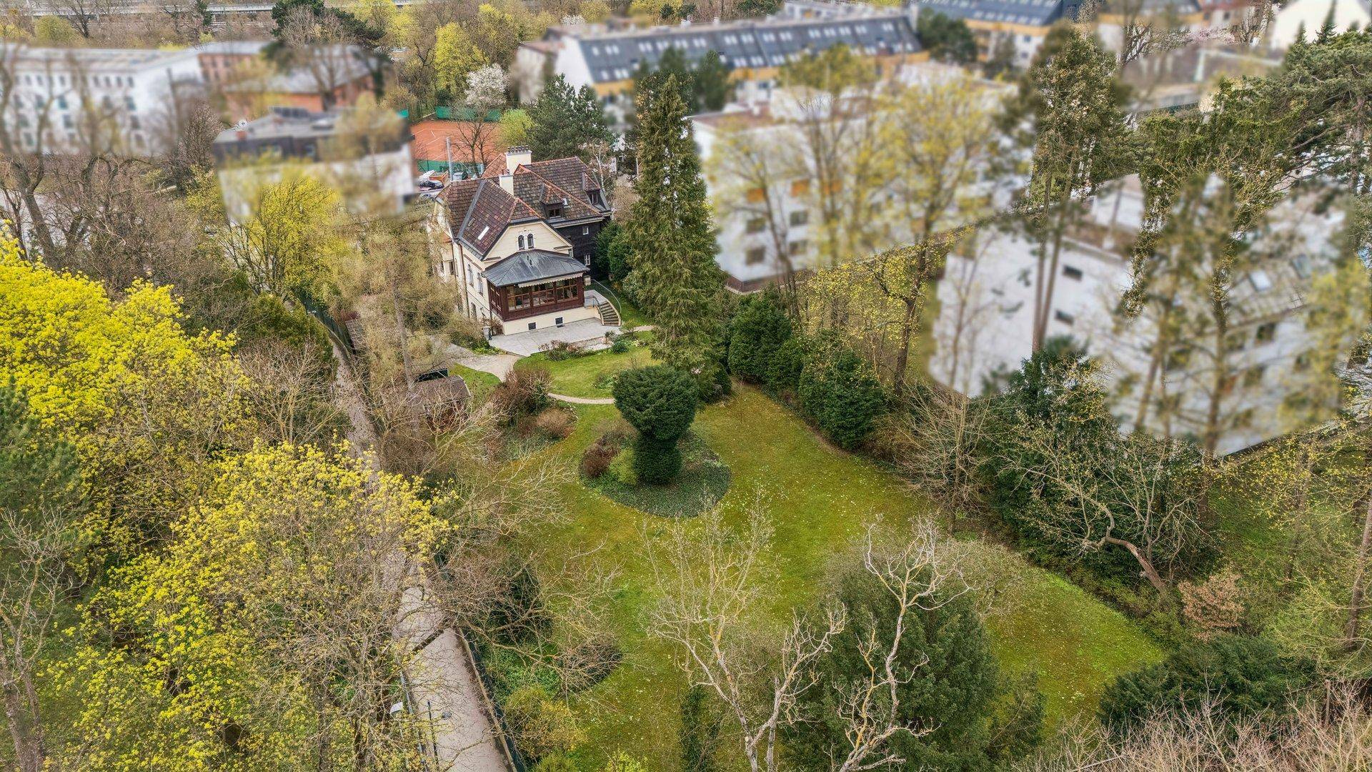 Luftaufnahme der historischen Villa mit weitläufigem Garten und umgebender Natur.