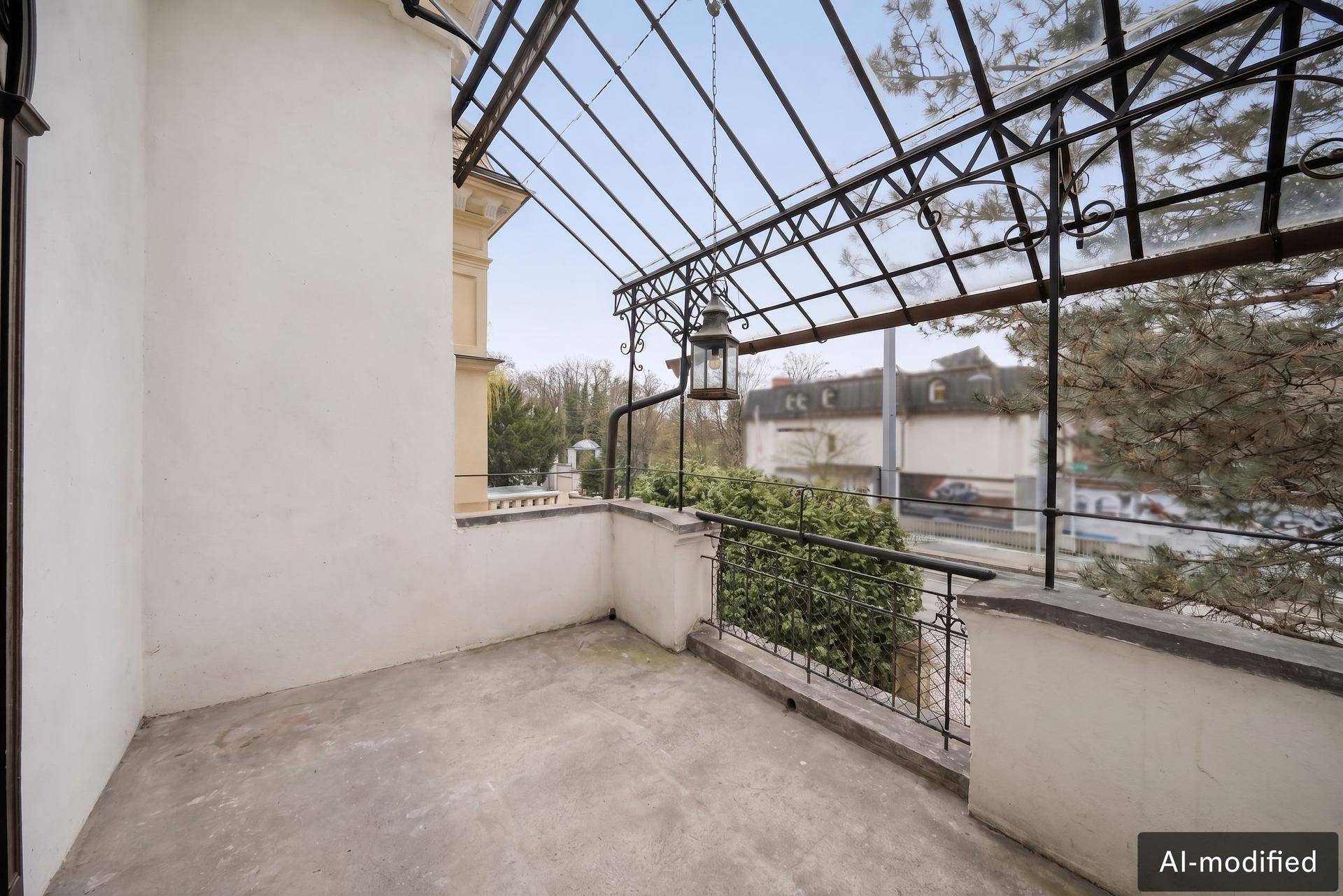 Überdachter Balkon mit schmiedeeisernem Geländer und Blick auf die Umgebung.