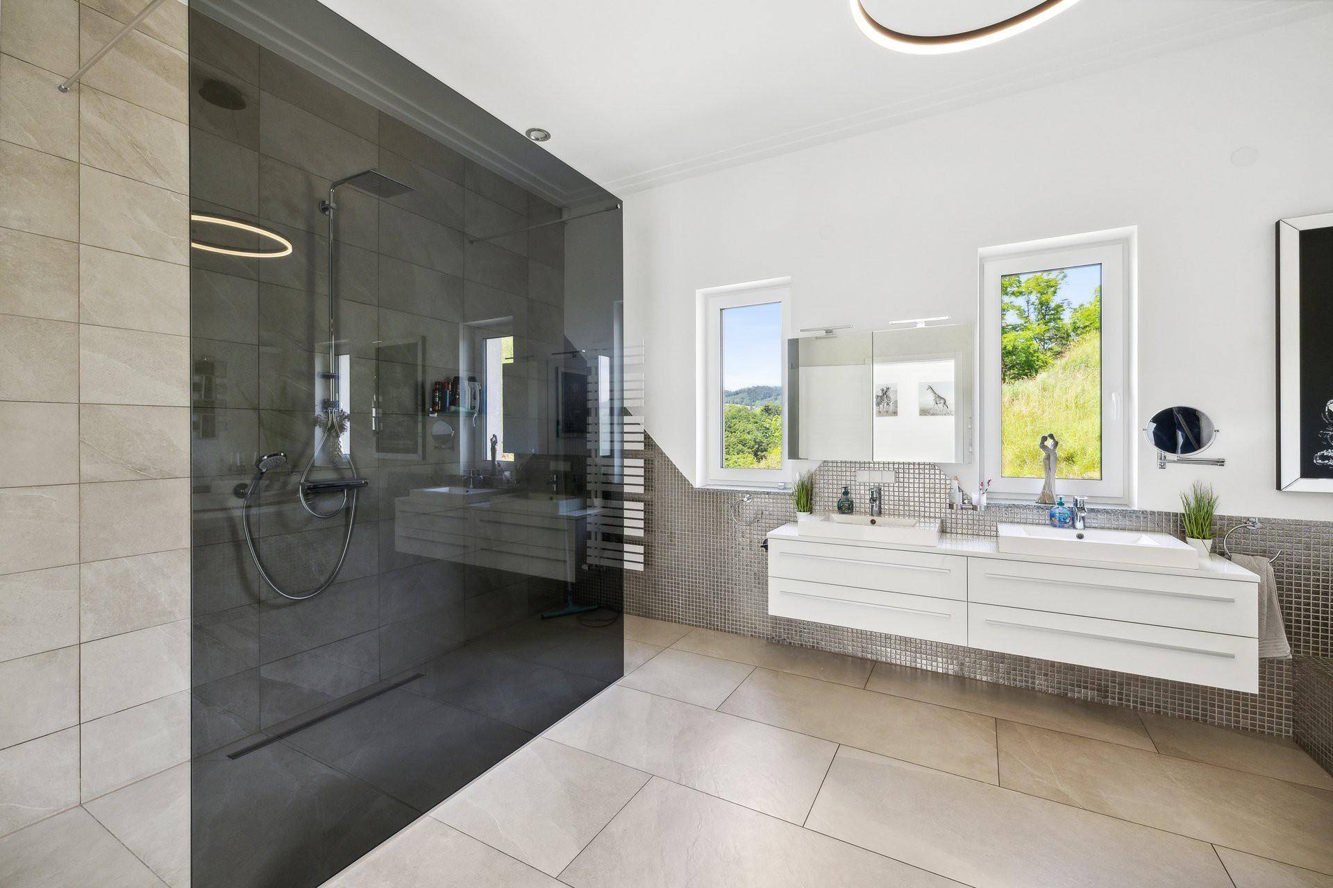 Modernes Badezimmer mit großer begehbarer Dusche, Doppelwaschbecken und Fenster mit Ausblick.