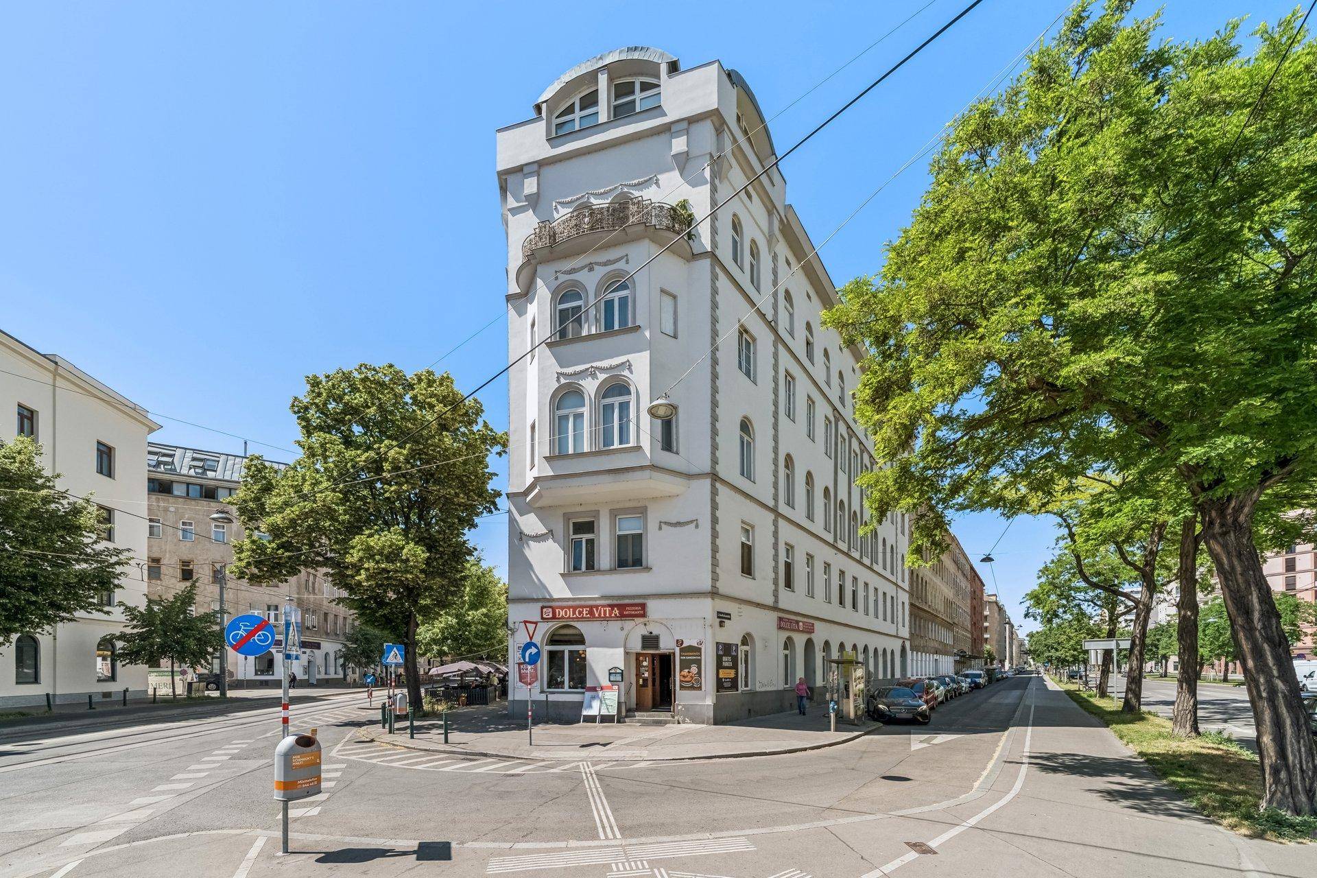 Historisches Eckgebäude in der Stadt mit Geschäften im Erdgeschoss.