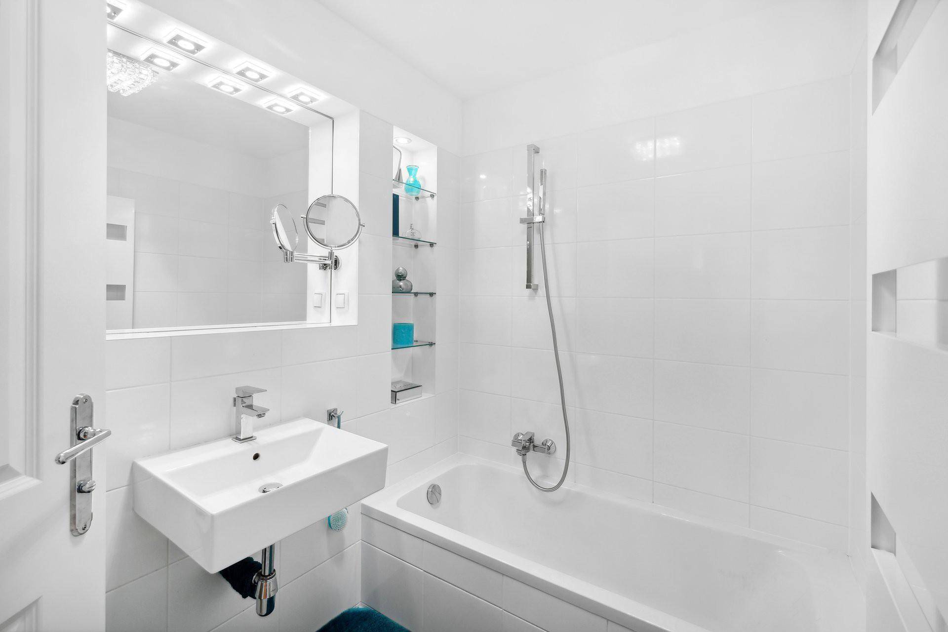 Modernes Badezimmer mit Badewanne, Waschbecken und weißen Fliesen.