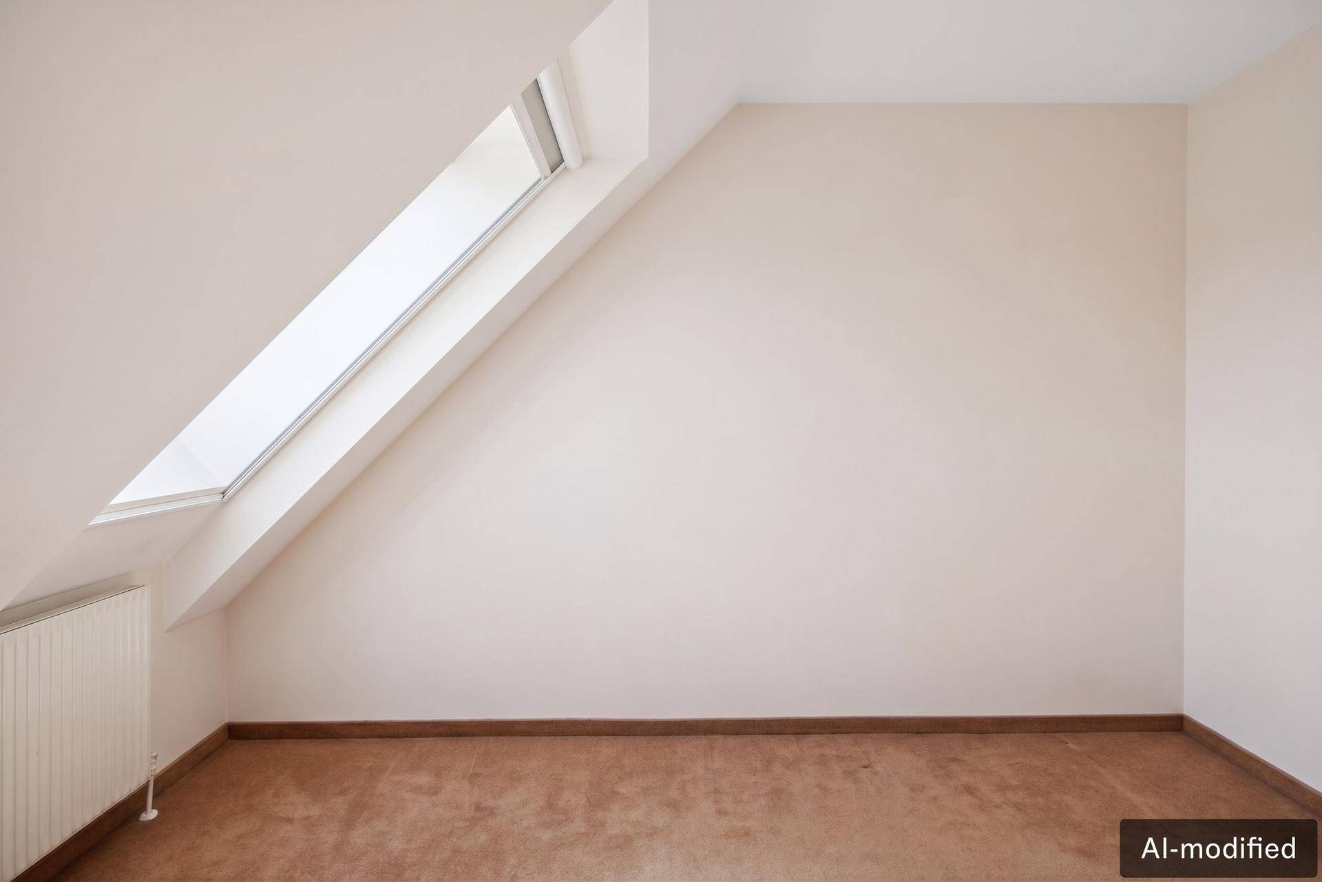Heller Raum mit Dachschräge, Dachfenster und Terrakotta-Fliesenboden.