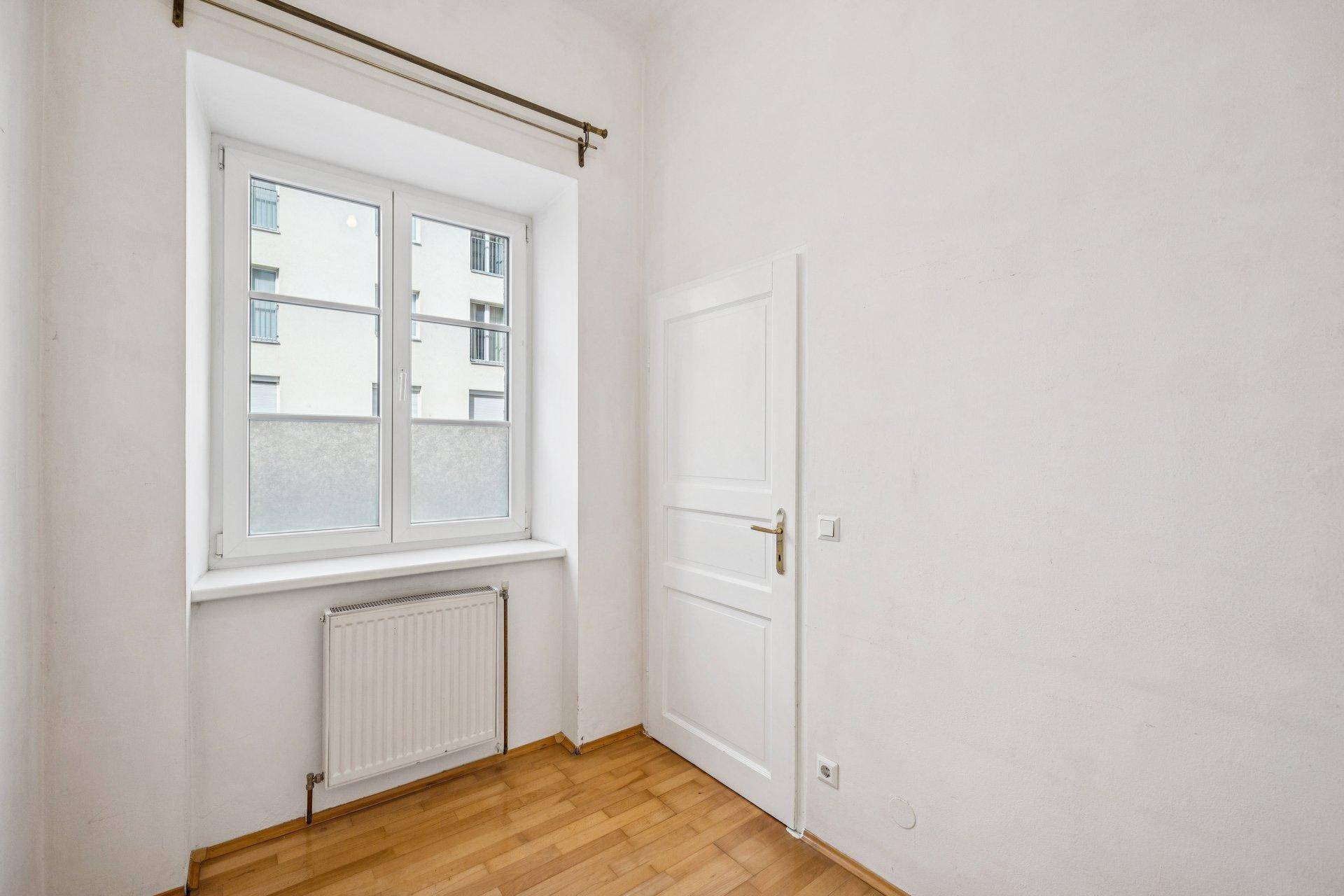 Kleineres Zimmer mit Parkettboden und Fenster, ideal als Schlaf- oder Arbeitszimmer.
