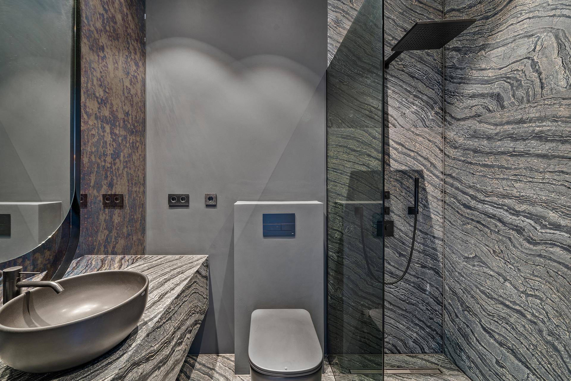 Modernes Badezimmer mit begehbarer Dusche, Wand-WC und eleganten Natursteinfliesen.