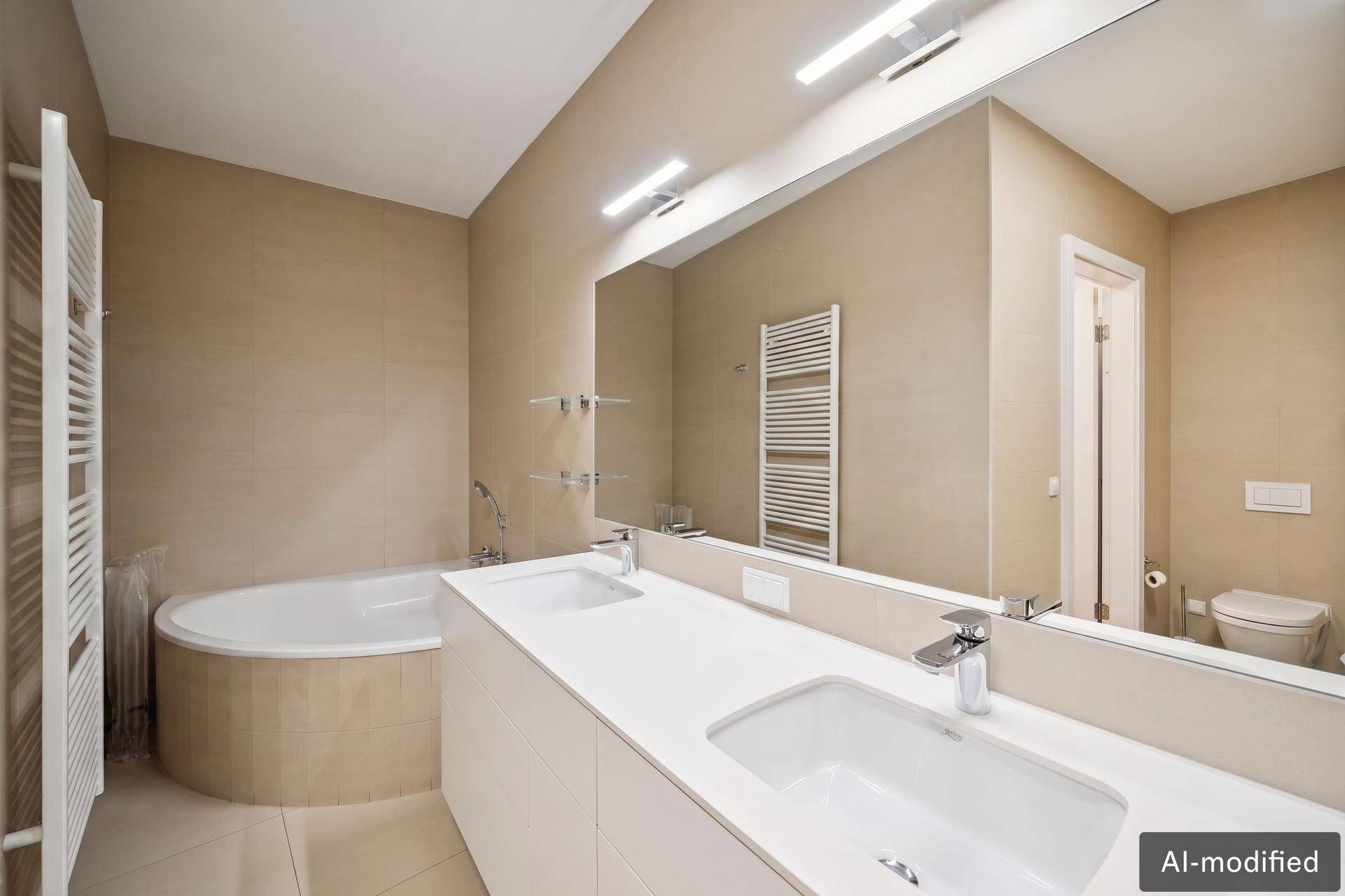 Modernes Badezimmer mit Doppelwaschbecken, Badewanne und beheiztem Handtuchhalter in beigen Farbtönen.