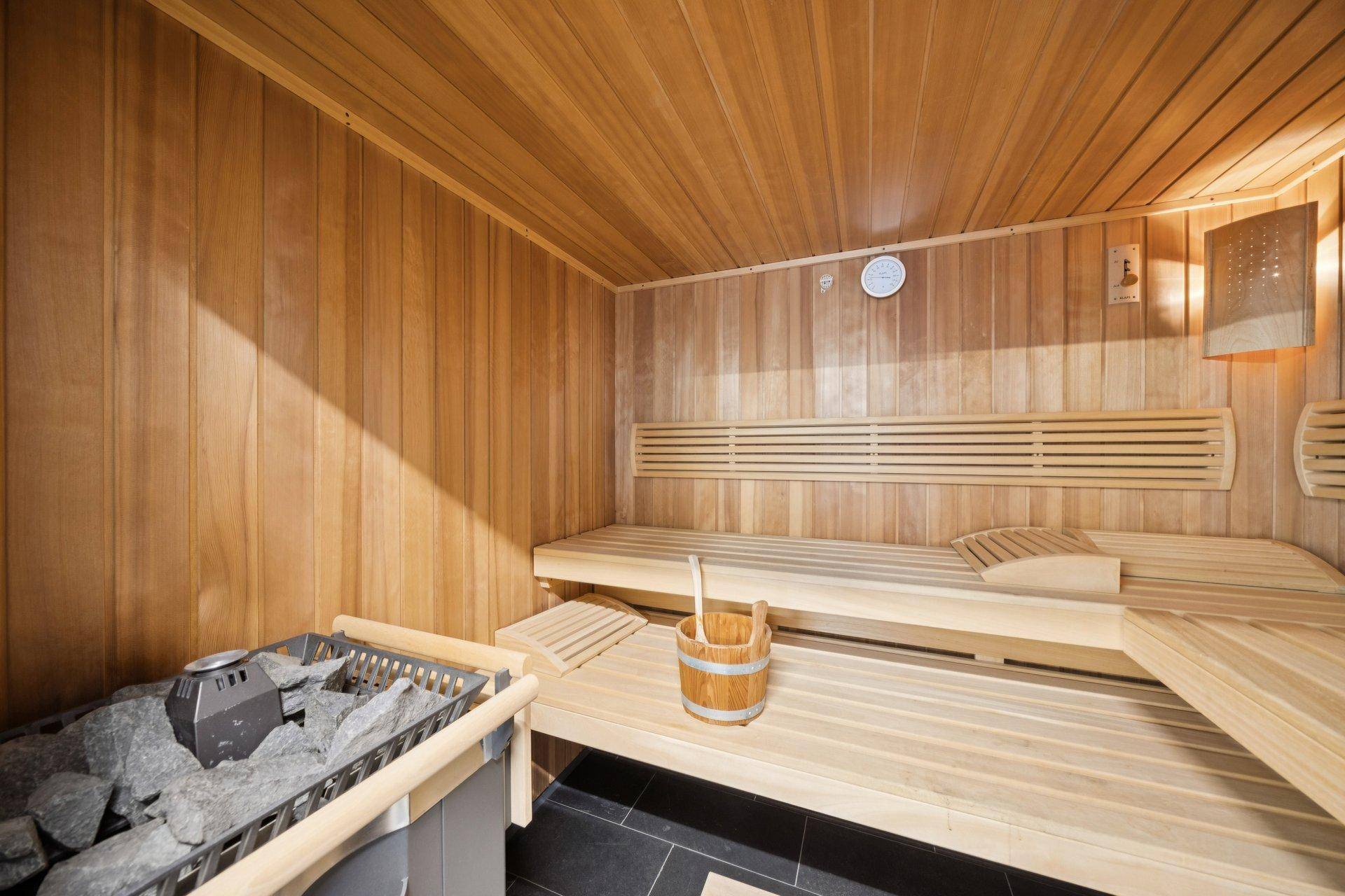 Private Sauna mit Holzverkleidung und traditionellem Saunaofen für entspannende Momente.
