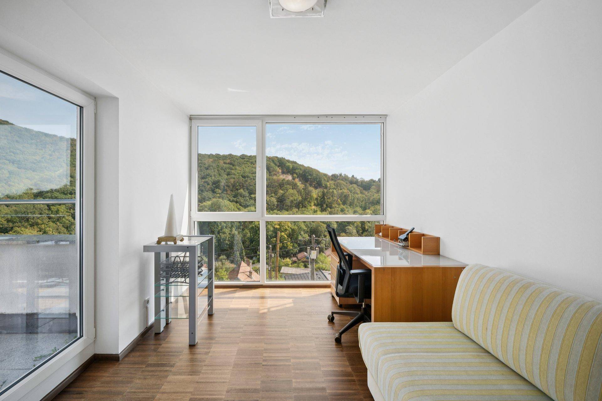 Helles Arbeitszimmer mit großen Fenstern und inspirierendem Blick ins Grüne.