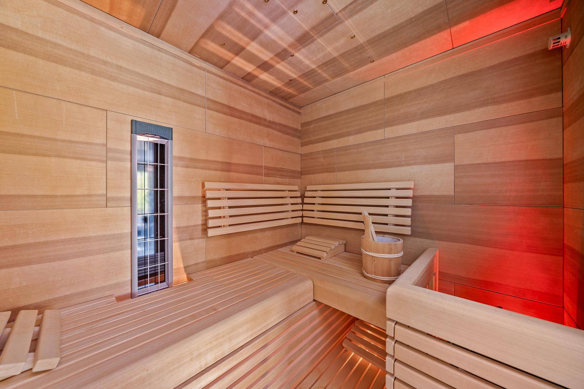 Moderne Sauna mit Holzverkleidung und bequemen Bänken, ideal zur Entspannung.