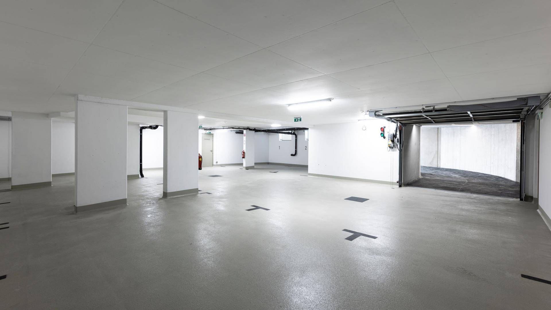 Geräumige Tiefgarage mit Betonboden und ausreichend Stellplätzen für Fahrzeuge.