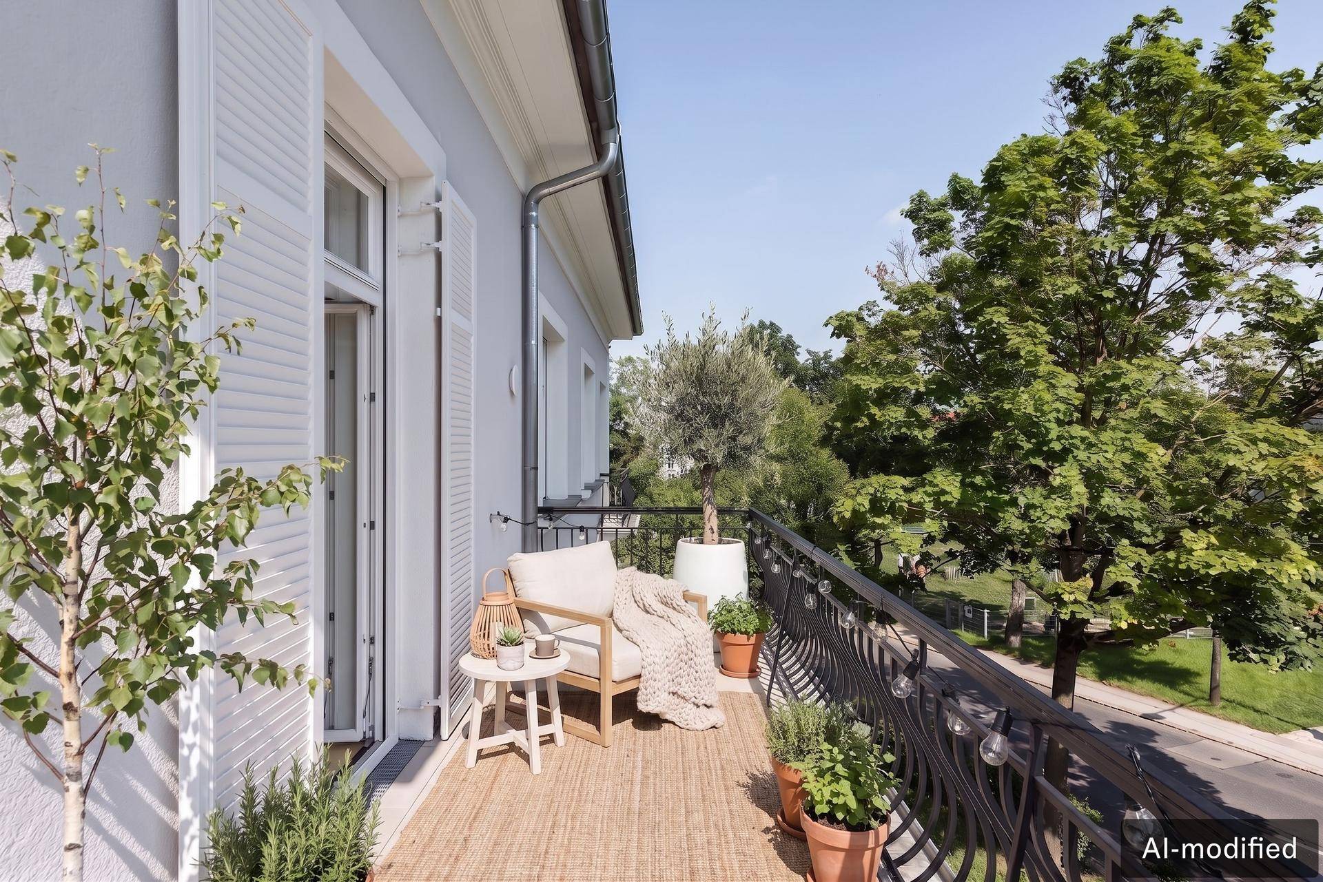 Gemütlicher Balkon mit Sitzgelegenheiten, Pflanzen und Blick ins Grüne an einem sonnigen Tag.
