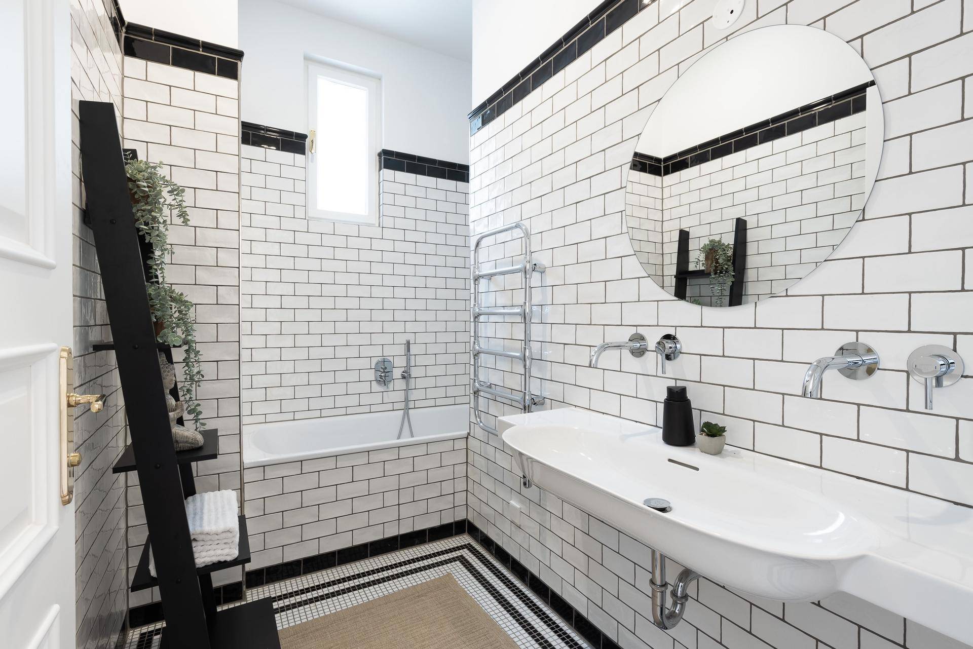 Modernes Badezimmer mit weißen U-Bahn-Fliesen, Badewanne und beheiztem Handtuchhalter.
