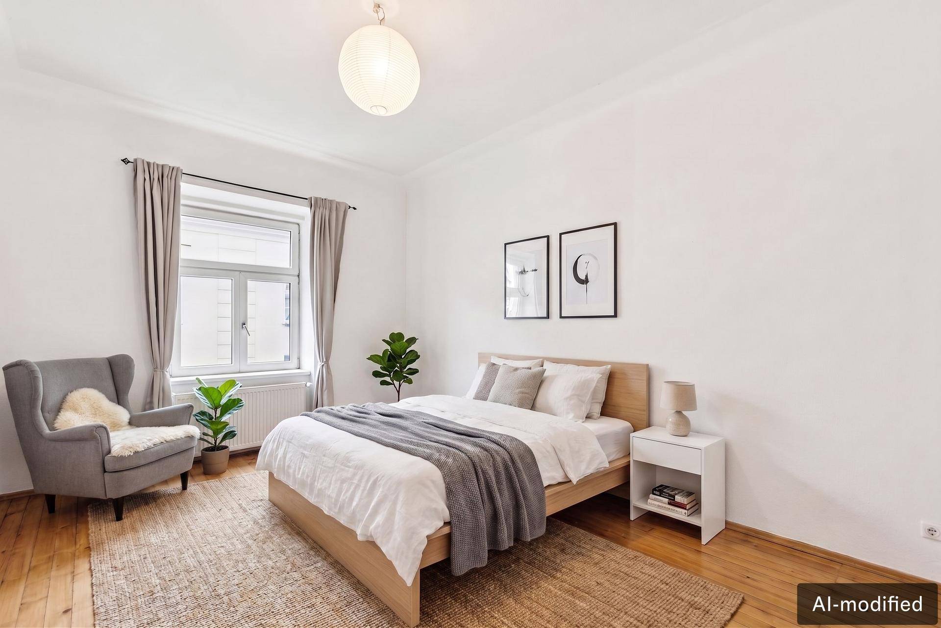 Helles Schlafzimmer mit Holzbett, Sessel und Parkettboden, modern und einladend eingerichtet.