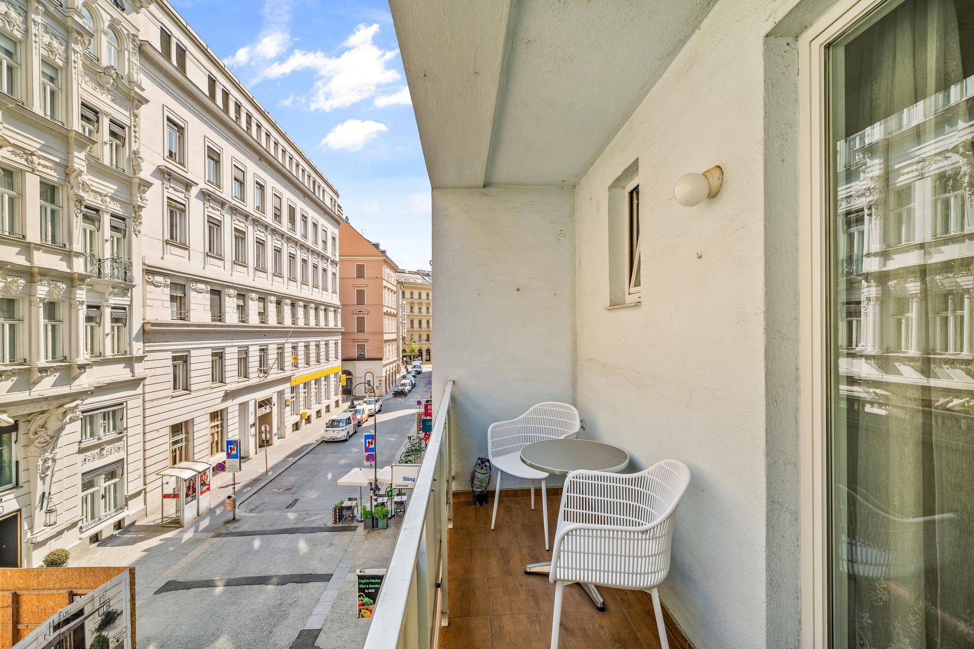 Balkon mit modernen Gartenmöbeln und Blick auf die städtische Umgebung.