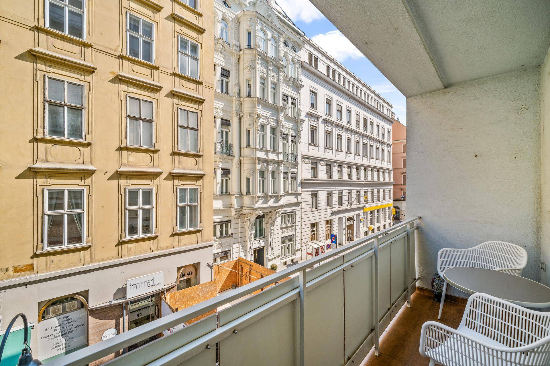 Balkon mit Blick auf die gegenüberliegenden Gebäude und die belebte Straße.