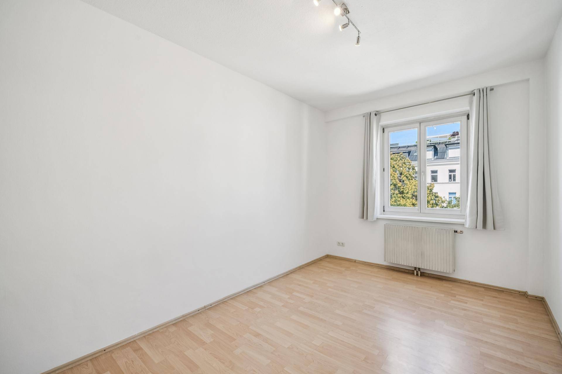 Schlafzimmer mit Holzboden und Fenster, das einen Blick auf die Umgebung bietet.